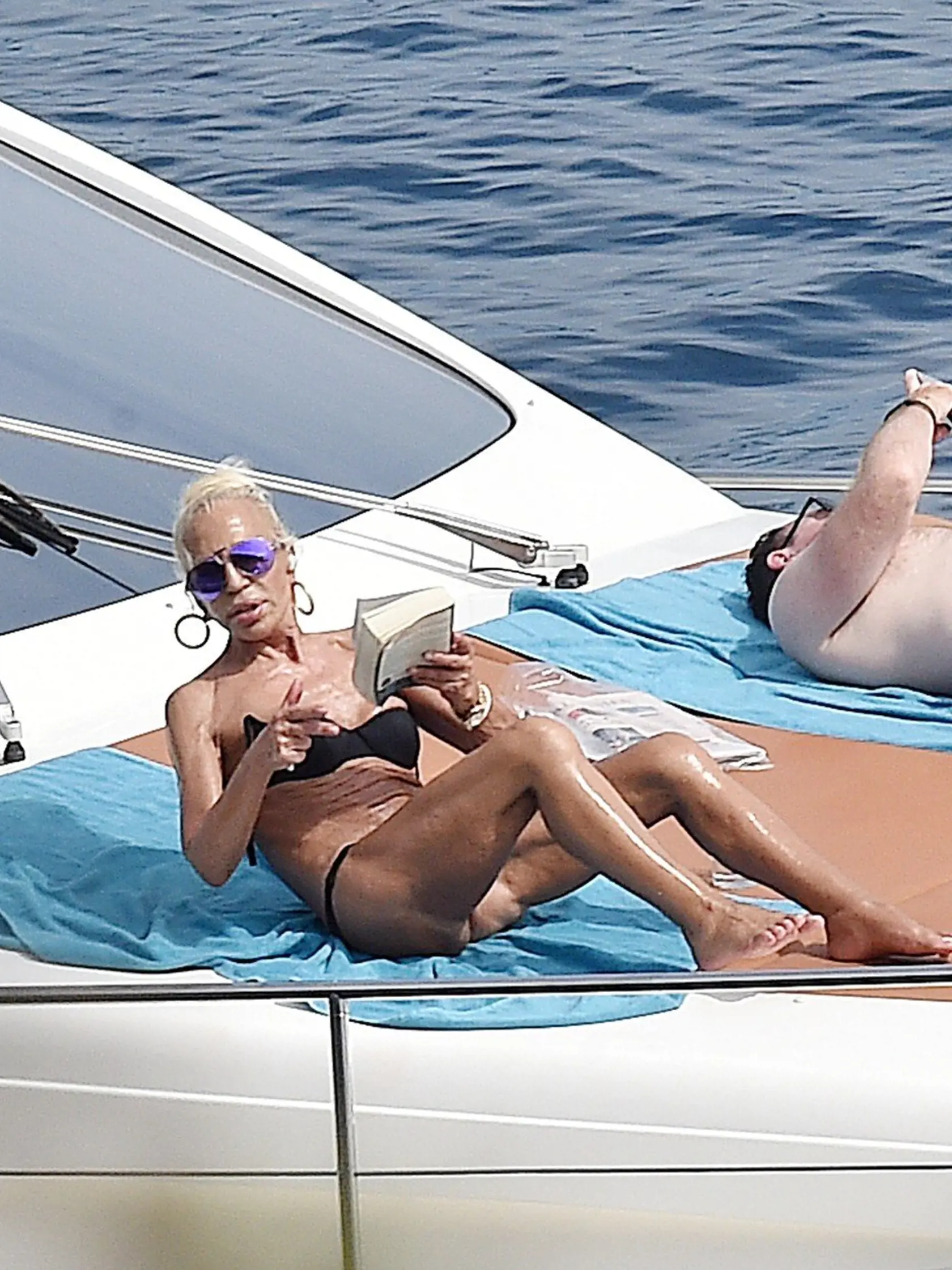 4 Sept 2016 - Portofino - Italy  *** PREMIUM EXCLUSIVE - MUST CALL FOR PRICING ***  **DOUBLE SPACE RATES APPLY FOR GERMAN CLIENTS**  *** STRICTLY NOT AVAILABLE FOR ITALY ***  Fashion Designer Donatella Versace and Daughter Allegra Versace Pictured relaxing onboard their Luxury Yacht while enjoying their summer on Holiday in Portofino, Donatella Versace seemed to be having some Trouble with seagulls as she's seen trying to scare them away from her yacht....!, Image: 300053175, License: Rights-man