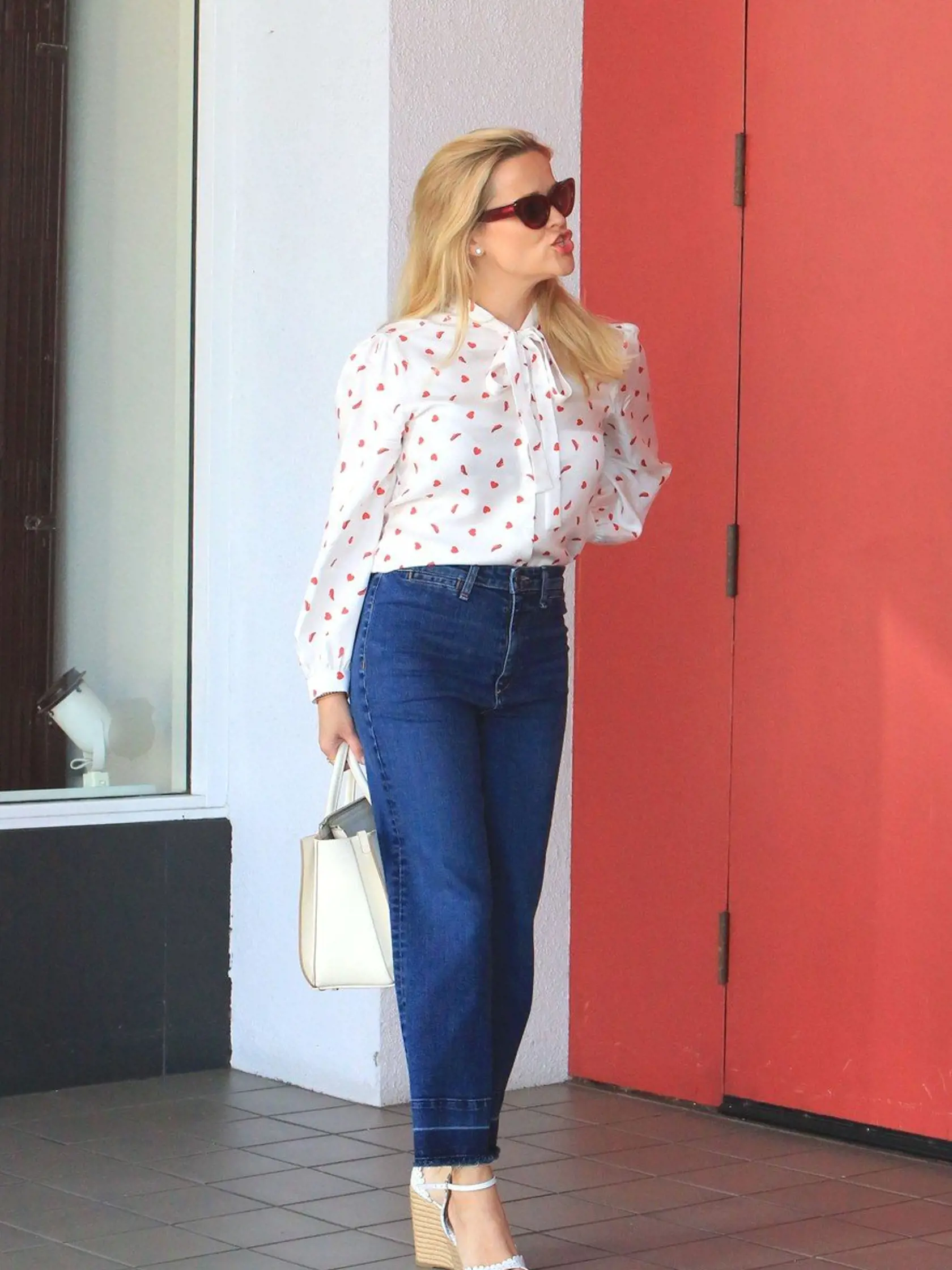 Monday, April 23, 2018 - Reese Witherspoon is feeling the spring season, sporting a white and red heart-print pussy bow blouse paired with wide-legged blue jeans and white wedge sandals as she steps out for lunch at R+D Kitchen in Santa Monica, CA.-, Image: 369467724, License: Rights-managed, Restrictions: , Model Release: no, Credit line: Profimedia, X17