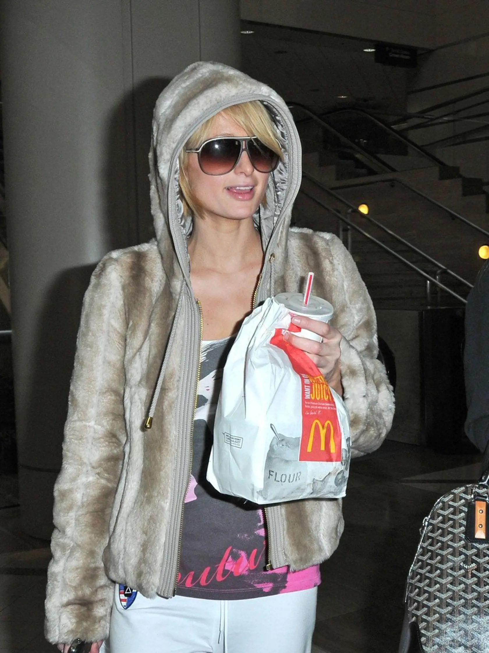 Paris and Nicky Hilton arrive at LAX with McDonald's take-out.  A close-up of Paris' cell phone reveals she is about to dial Pamela Anderson.   February 18, 2009 Job: 90218NC1 Los Angeles, CA, Image: 30026053, License: Rights-managed, Restrictions: 000, Model Release: no, Credit line: Profimedia, Bauer Griffin