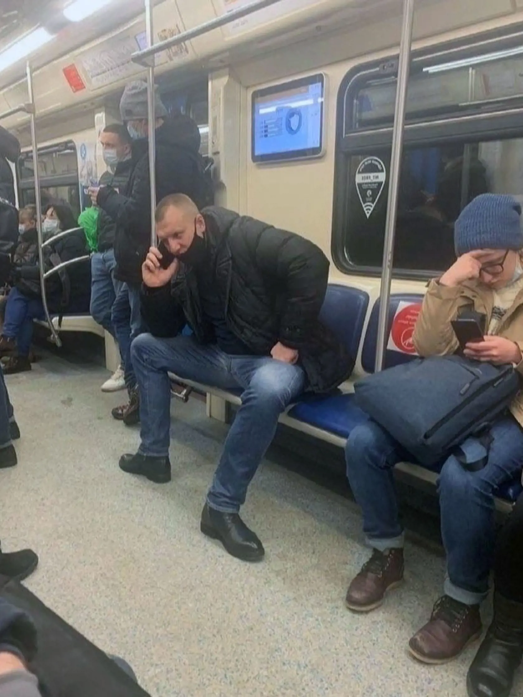 Muž si síce rúško stiahol pod nos, no pred covidom sa chráni odstupom od ľudí. Zaberá preto rovno dve miesta v preplnenom metre.
