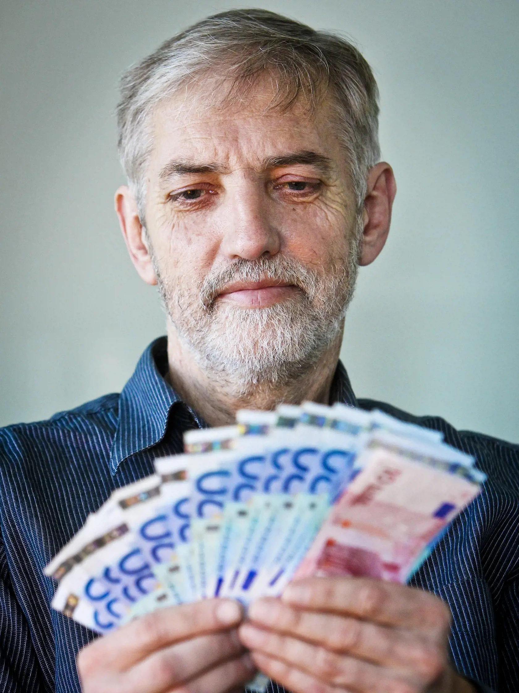 Na ilustracnej snimke starsi muz drzi v rukach eurobankovky v celkovej hodnote 300 eur.