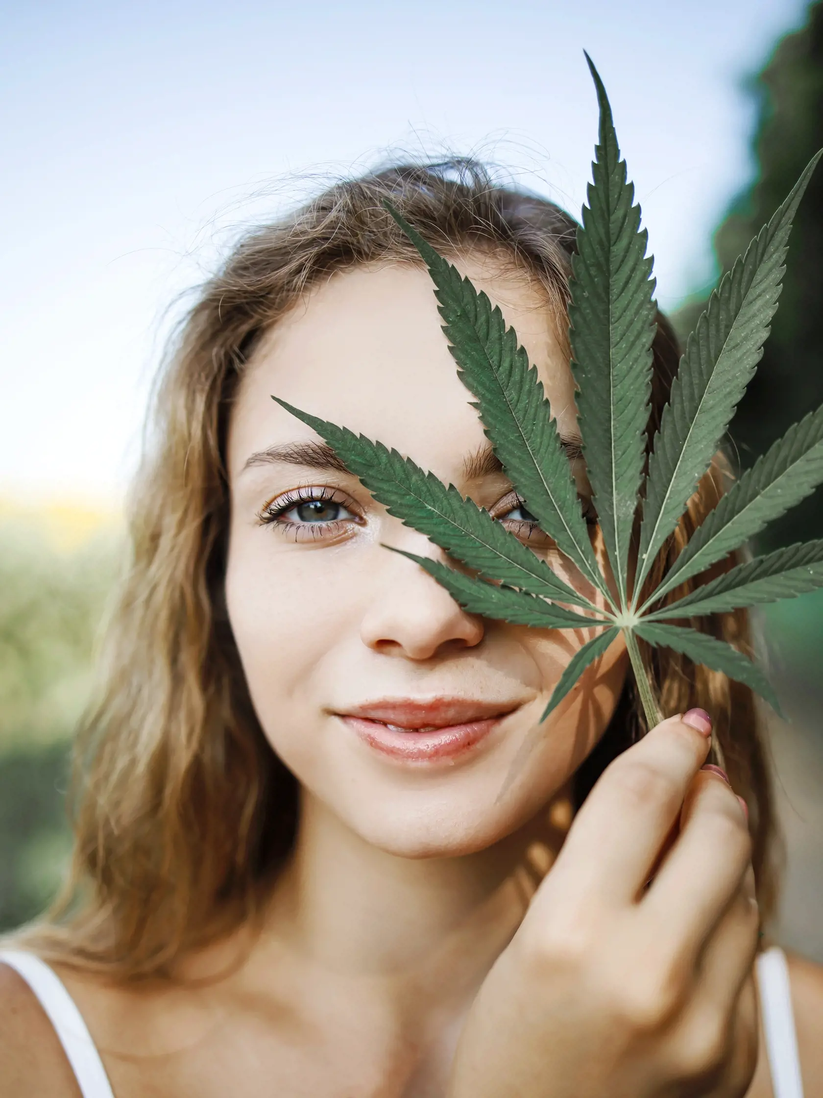 Portrait,Of,A,Young,Girl,Holding,Green,Hemp,Leaves,Outdoor