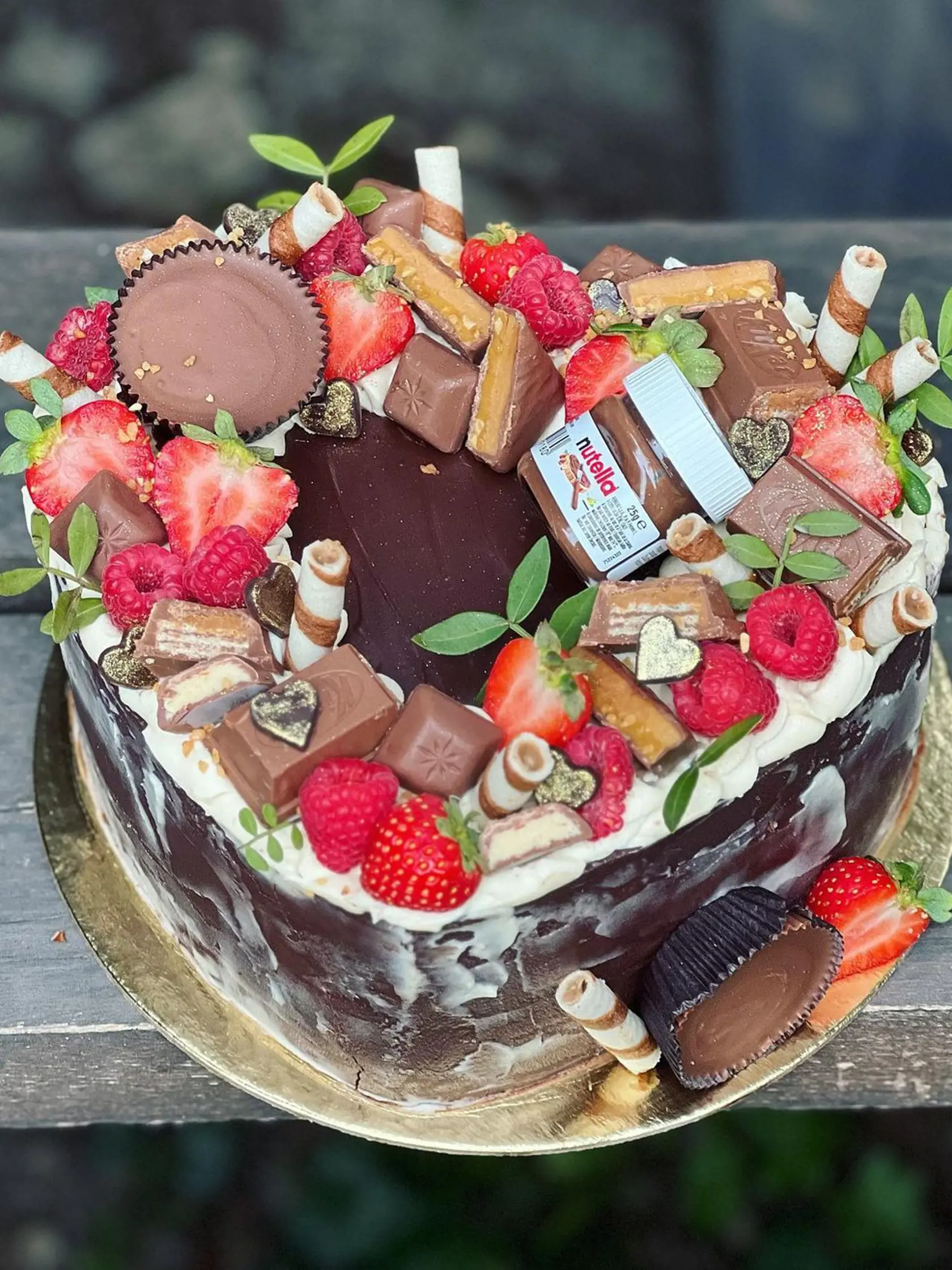 "Čokoládová bomba - hutný čoko korpus s banánom , ľahkým arašidovým krémom + nasekaný Kitkt peanutbutter pre túto moju čokoládu pínatbaterovú , preto aj všetky ozdoby sú pínatbaterové (okrem nutelly) + jej obľúbené ovocie na torte..." napísala k torte cukrárka a Jasminina blízka priateľka Razija.