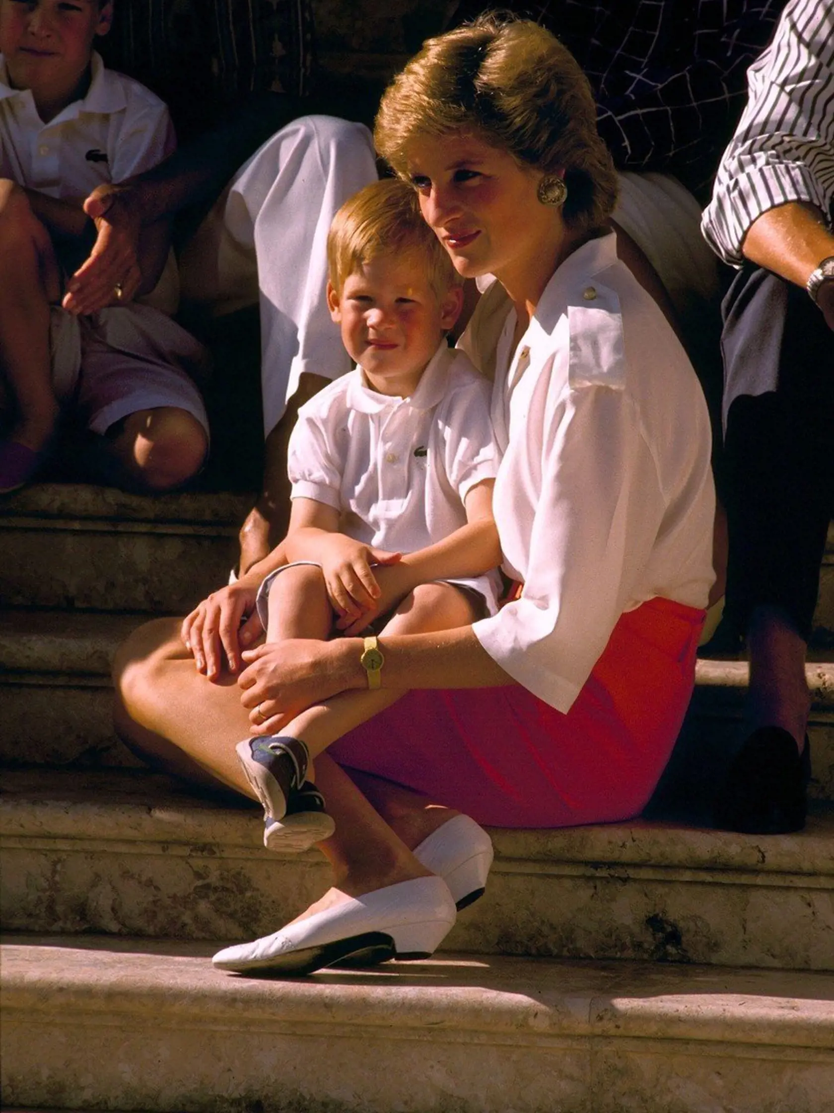 Princezná Diana drží na (nahých) kolenách princa Harryho na dovolenke v Španielsku v roku 1988.