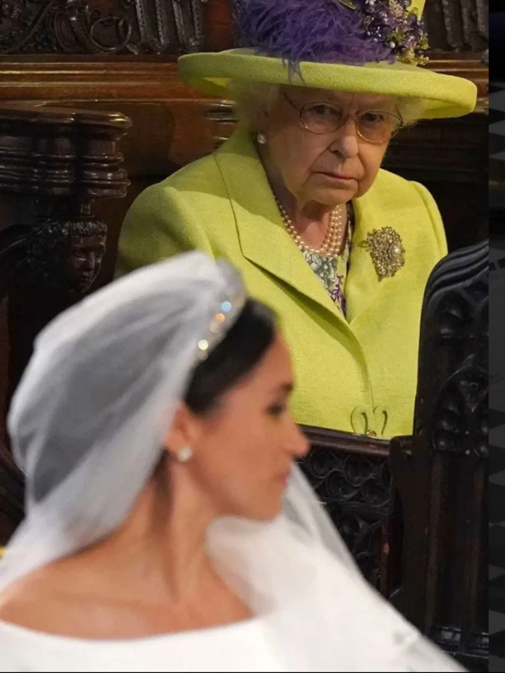 Kráľovná Alžbeta II. zazerá na Meghan.