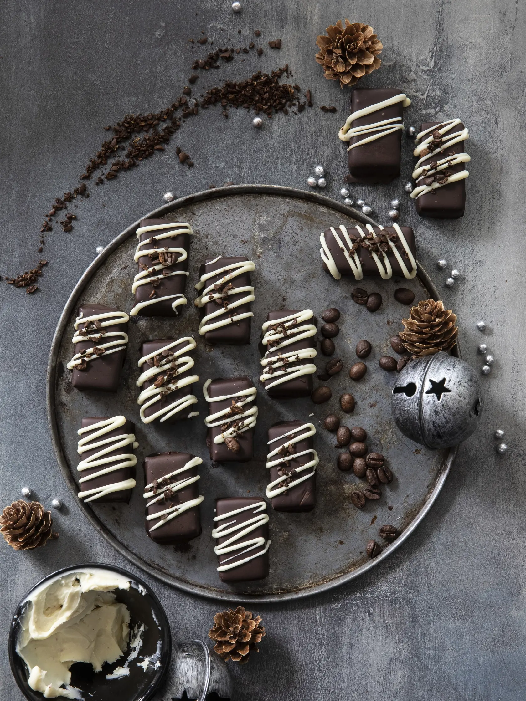 kavové pralinky v horkej čokoláde, 5x inak

recept:
30-40 KUSOV, PRÍPRAVA 45 MINÚT, CHLADENIE 2 HODINY
• 450 g kvalitnej čokolády (54 %) • 230 g smotany na šľahanie
• 2 lyžičky mletej kávy
• 85 g masla izbovej teploty
Na polevu:
• 200 g tmavej čokolády (72 %) Tesco • 1 lyžica masla
• 50 g bielej čokolády
• kávové zrná, nahrubo nasekané
1. Čokoládu nasekajte a dajte do misy.
V hrnci zohrejte smotanu zmiešanú s kávou pod bod varu. Potom ňou prelejte čokoládu.