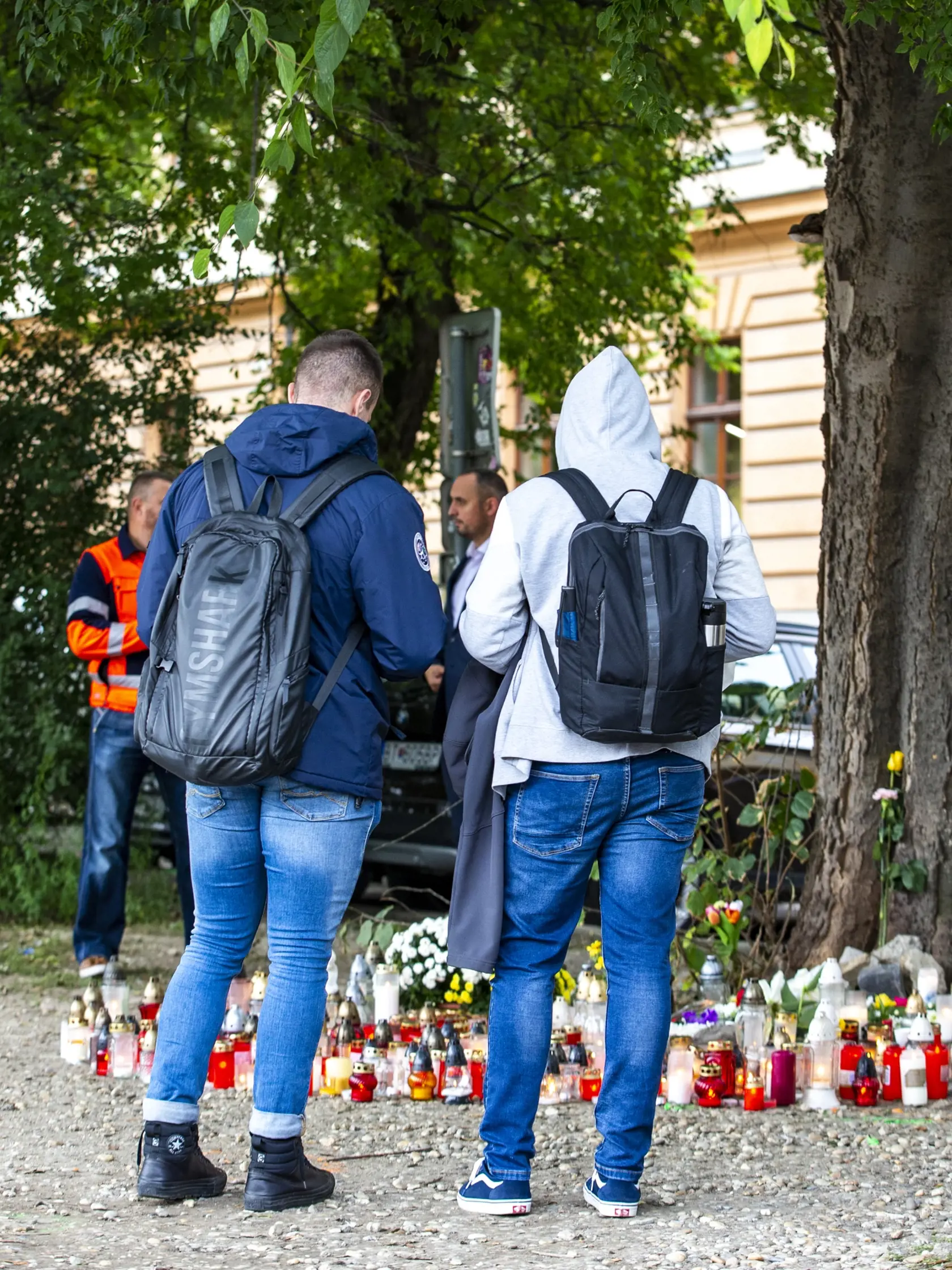 Študenti prichádzajú na miesto nešťastia, aby zapálili sviečku na pamiatku svojich nebohých spolužiakov.