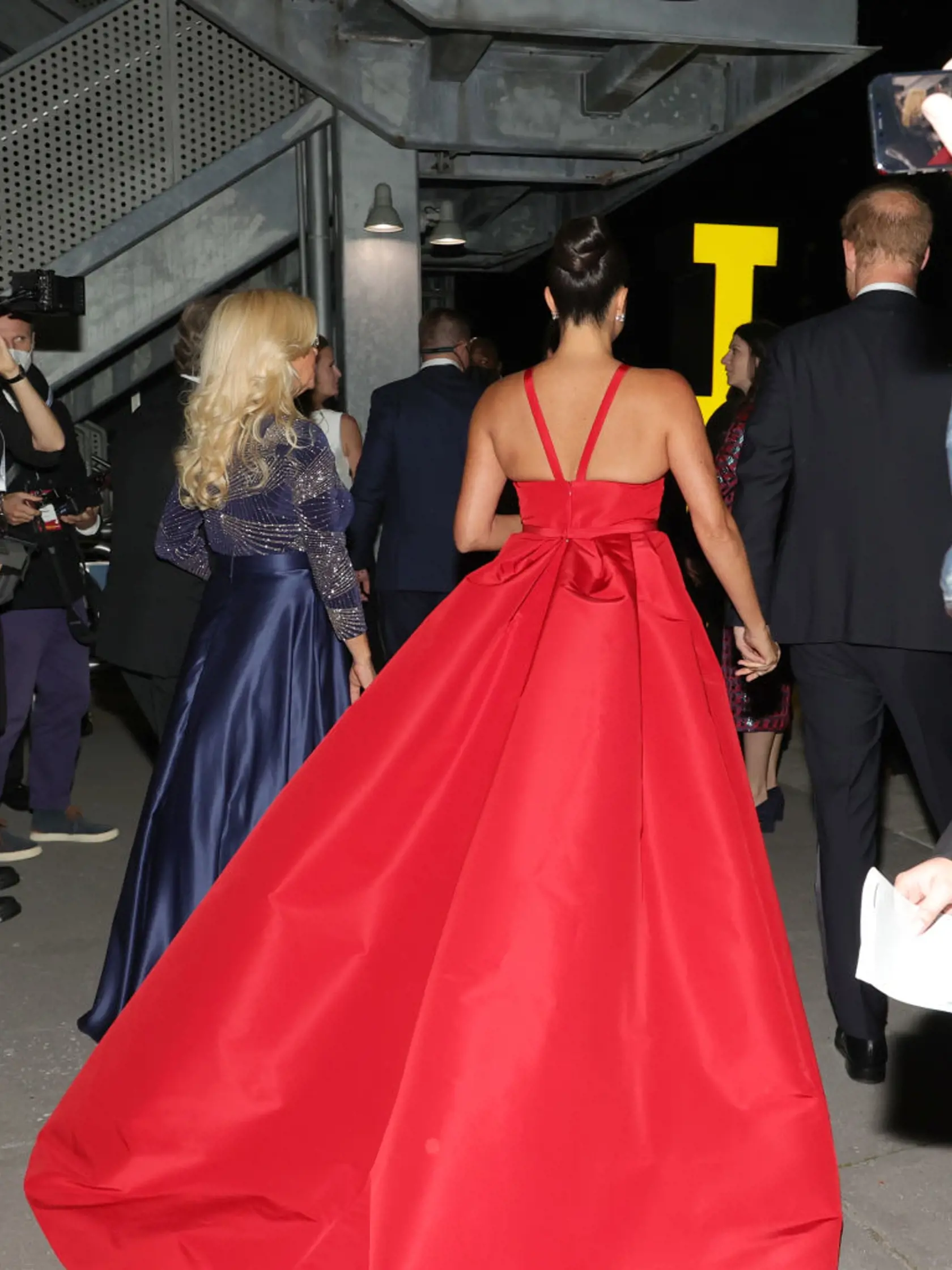 Meghan Markle pútala pohľady v ohnivo červených šatách.