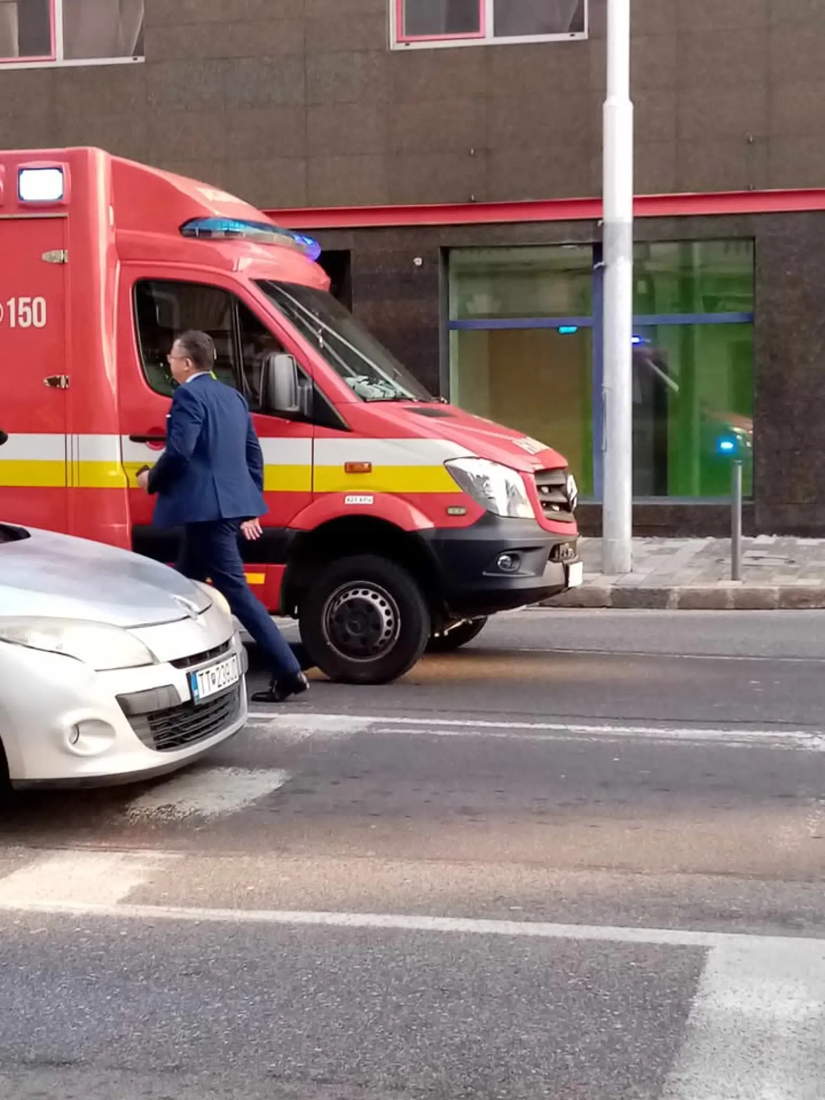Na fotografii minister financií Ladislav Kamenický (Smer) na mieste nehody prechádza pri hasičskom vozidle.