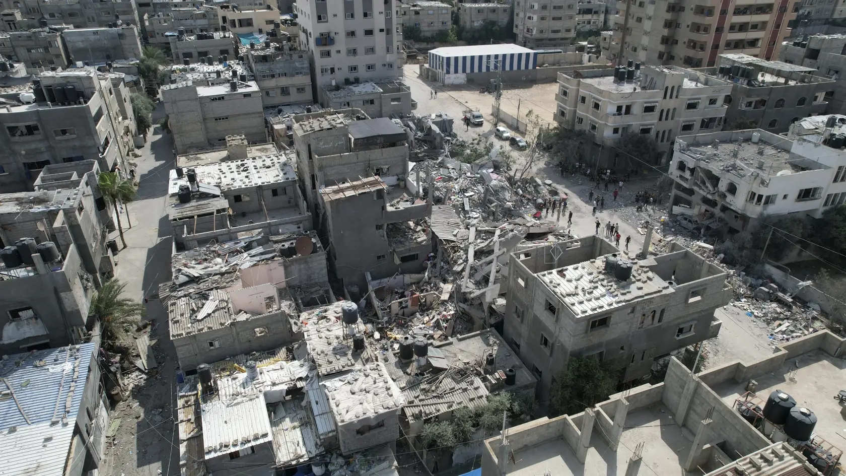 WA 32 utečenecký tábor Nuseirat - Palestínčania stoja pri budove zničenej po izraelskom raketovom útoku v utečeneckom tábore Nuseirat, ktorý je jedným z ôsmich utečeneckých táborov v pásme Gazy v pondelok 16. októbra 2023. Izraelská armáda leteckými útokmi reagovala na bezprecedentný útok palestínskeho hnutia Hamas. V sobotu 7. októbra z pásma Gazy na Izrael odpálil tisíce rakiet a stovky jeho bojovníkov prekonali zátarasy na hraniciach. V dôsledku útokov zahynulo v Izraeli už vyše 1400 ľudí. Iz