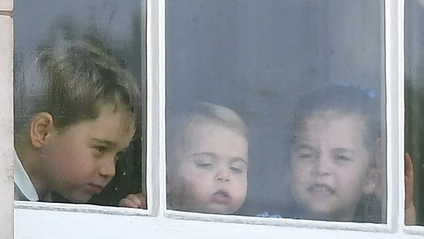 George, Charlotte a Louis sledujú oslavy zokna Buckinghamského paláca.
