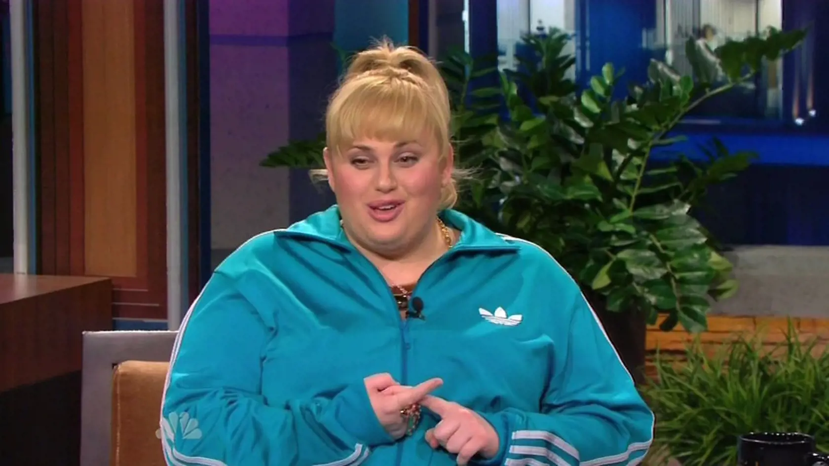 10 April 2013 - Los Angeles - USA **** STRICTLY NOT AVAILABLE FOR USA *** Rebel Wilson wears hilarious pink Poodle trainers as she recounts rude Russell Crowe story on The Tonight Show with Jay Leno. The Aussie actress and comedienne arrived at the US late night chat show dressed in a blue Adidas tracksuit - and neon pink trainers with toy poodles attached to the top. When host Leno commented on them she quipped: "I like them, they take attention away from my double chin!" Leno then asked her ab