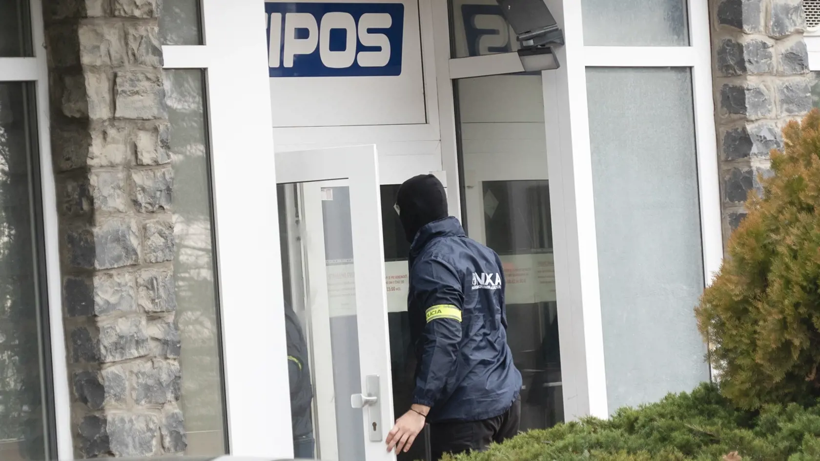 NAKA vchádza do budovy Tiposu, v ktorej urobila raziu a zadržala Jána Barcziho, teda riaditeľa spoločnosti.