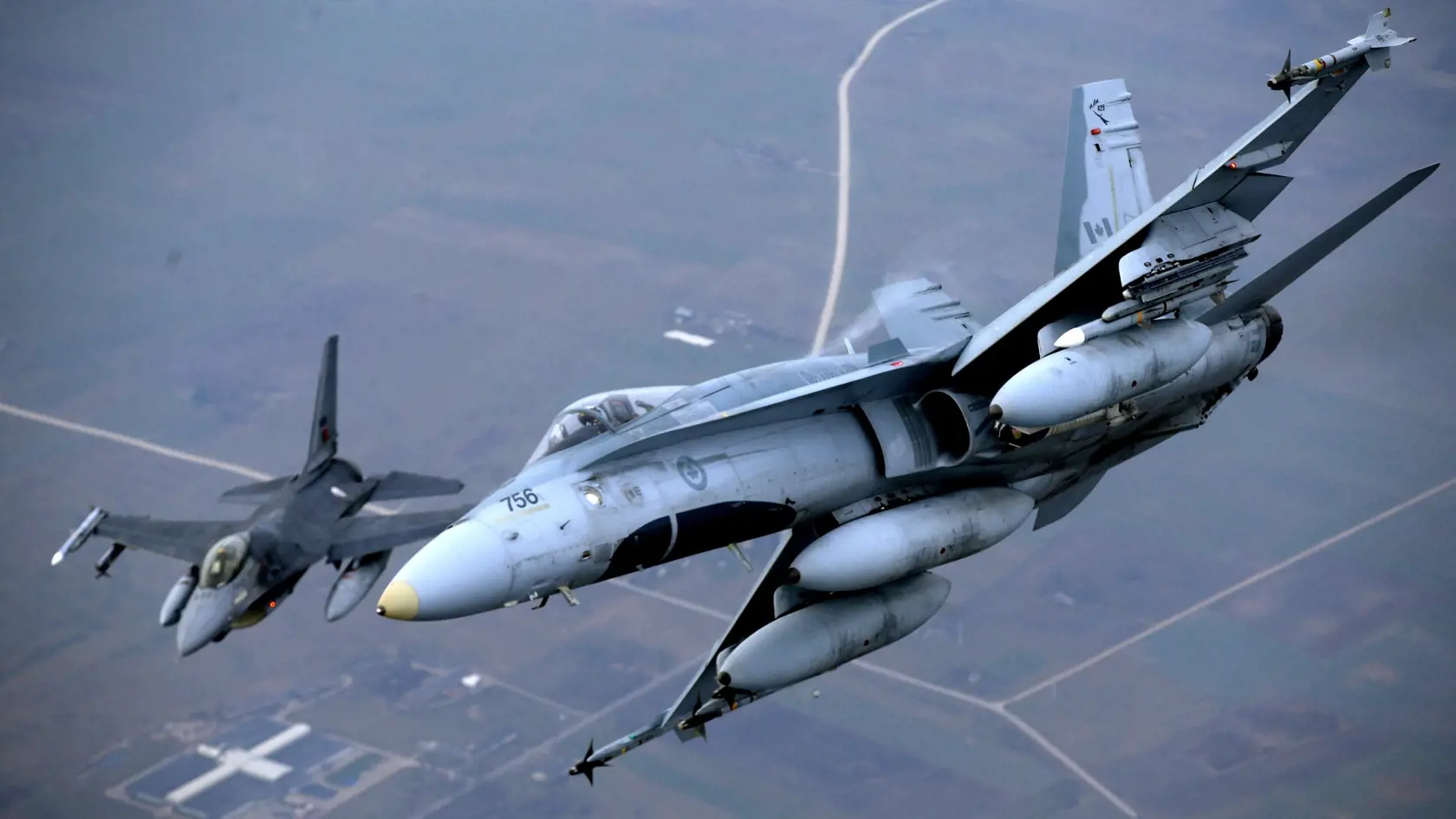 SY 37 Vilnius - Vojenská stíhačka F-16 portugalského letectva (vľavo) a stroj kanadského letectva F-18 počas hliadkového letu v rámci misie NATO Baltic Air Policing v litovskom vzdušnom priestore 20. novembra 2014. NATO má momentálne v oblasti Pobaltia 16 stíhačiek, ktoré sledujú vzdušné priestory Litvy, Lotyšska a Estónska. FOTO TASR/AP
A Portuguese military fighter jet, right, and a Canadian military fighter jet participating in NATO's Baltic Air Policing Mission operate in Lithuanian airspace