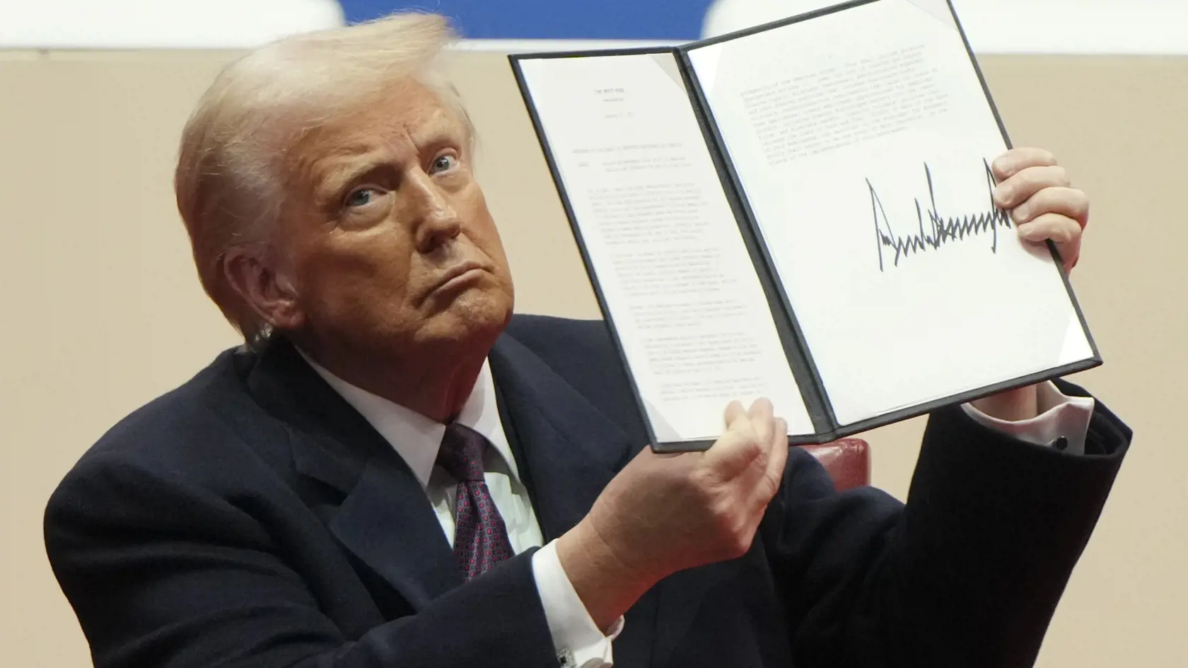 Americký prezident Donald Trump drží podpísané dokumenty vo washingtonskom komplexe Capital One 20. januára 2025.