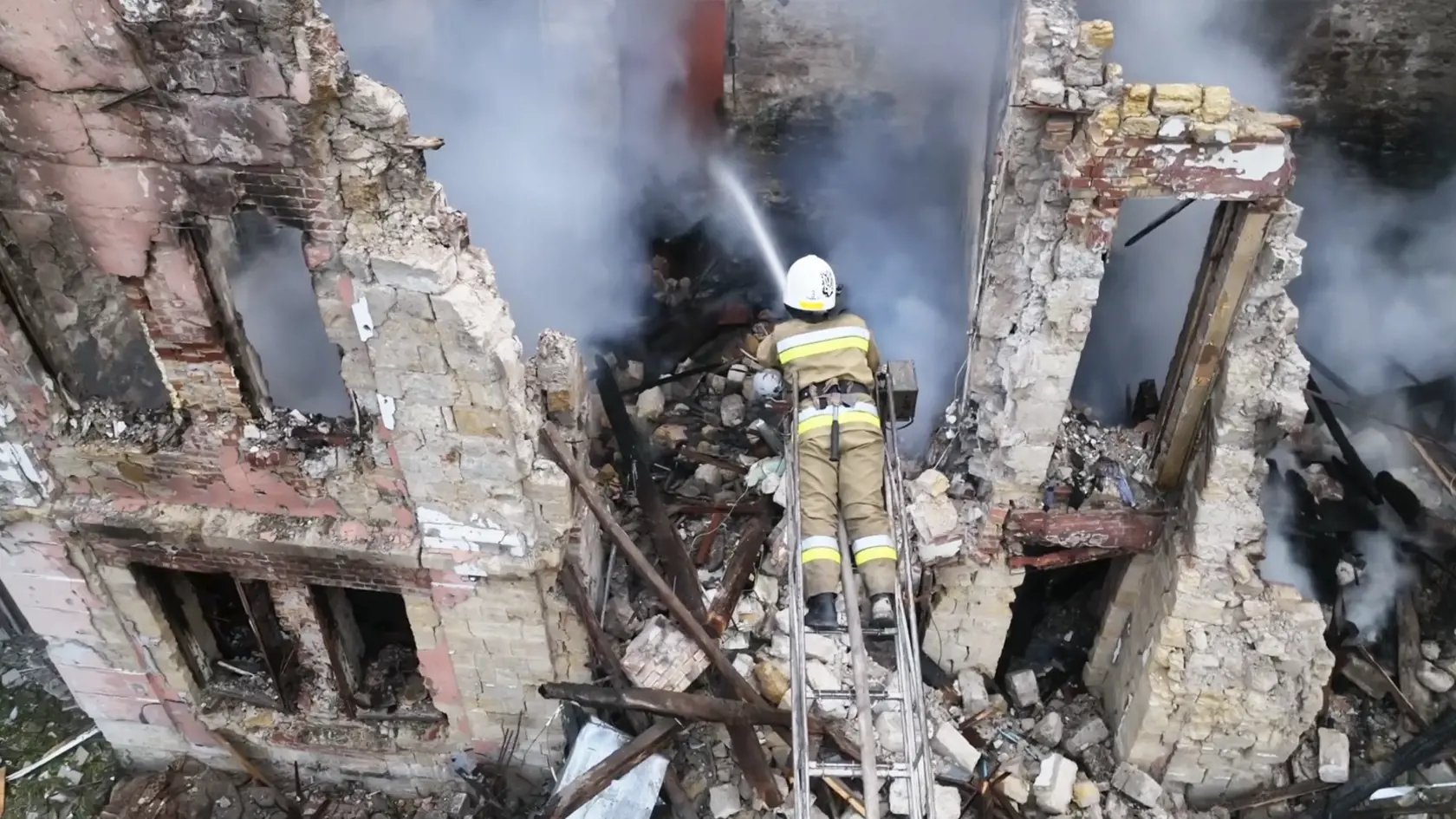 Na videosnímke hasiči zasahujú  na mieste zničenej budovy po ruskom raketovom útoku v ukrajinskom Mykolajive 20. júla 2023.