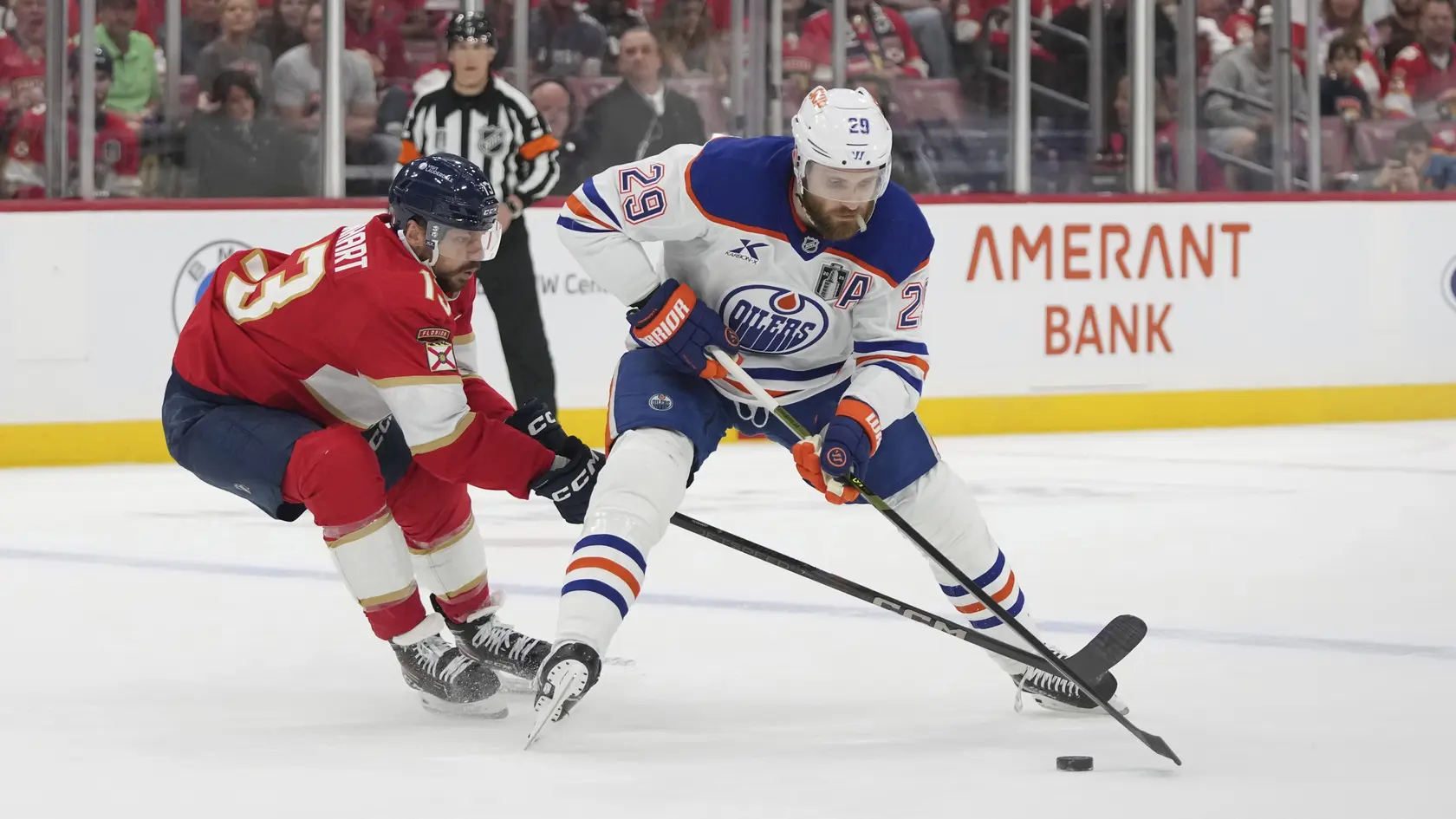 Sam Reinhart (vľavo) a Leon Draisaitl v súboji o puk.