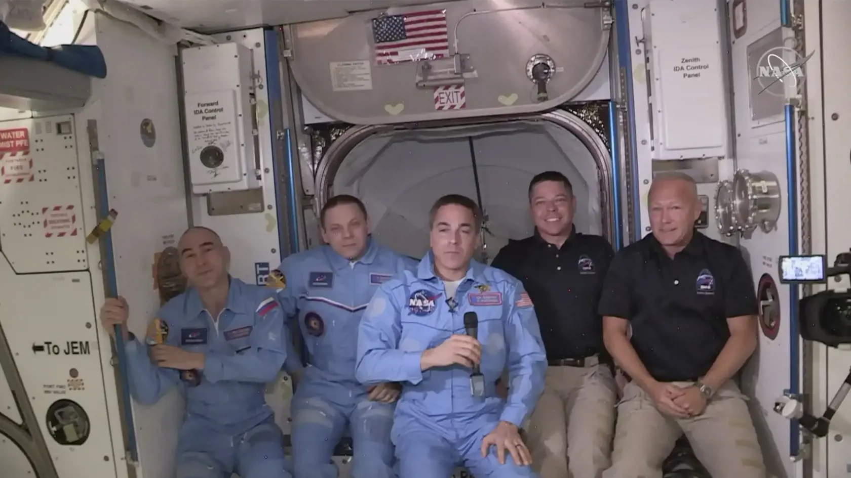 Posádka americkej vesmírnej lode Crew Dragon -  astronauti Robert Behnken (druhý sprava) a Douglas Hurley - pózujú s tamojšou posádkou po tom, čo prešli do Medzinárodnej vesmírnej stanice (ISS).