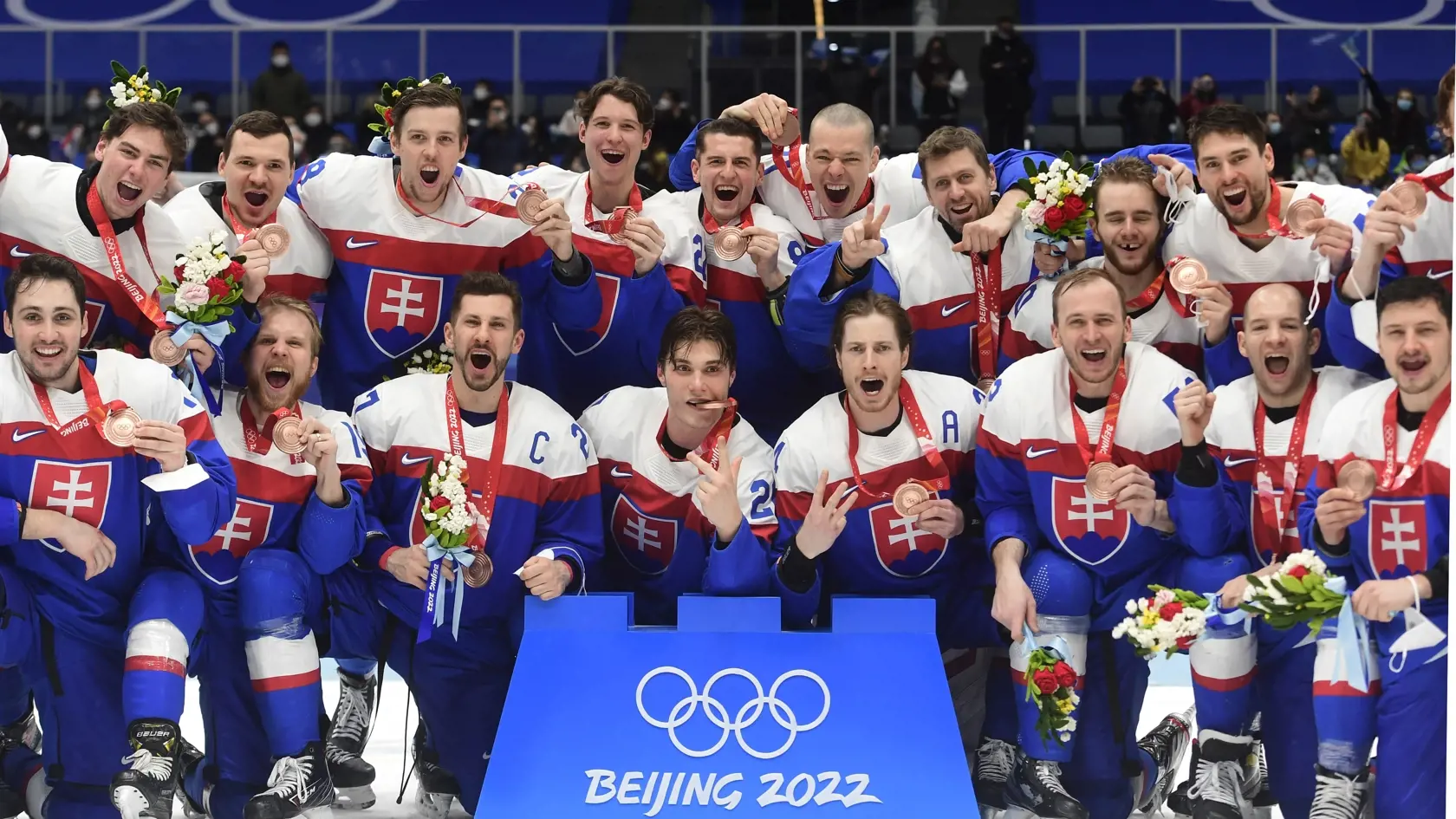 Slovenskí hráči pózujú s bronzovými medailami po zápase olympijského turnaja v hokeji mužov o bronz Slovensko - Švédsko na ZOH 2022 v Pekingu v sobotu 19. februára 2022. Na símke horný rad zľava Šimon Nemec, Miloš Kelemen, Martin Gernát, Samuel Kňažko, Adrián Holešinský, Marek Ďaloga, Branislav Konrád, Miloš Roman, a Samuel Takáč. Dolný rad zľava Tomáš Jurčo, Michal Krištof, Marek Hrivík, Juraj Sláfkovský, Peter Cehlárik, Martin Marinčin, Mislav Rosandič a Libor Hudáček.