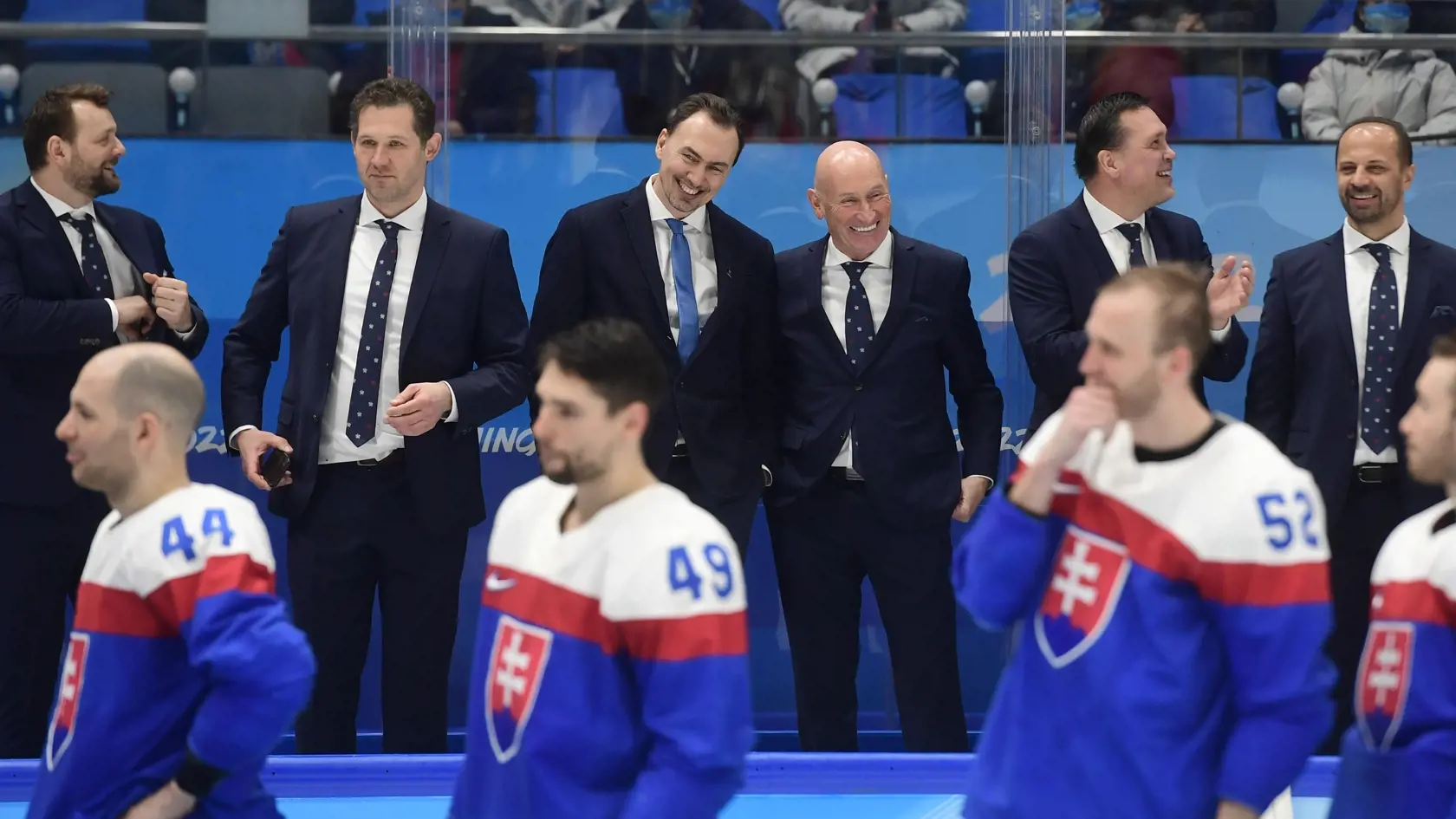 Na snímke v pozadí slovenská striedačka zľava asistent trénera Andrej Podkonický, tréner brankárov Ján Lašák, prezident SZĽH a generálny manažér slovenských hokejistov Miroslav Šatan, tréner slovenských hokejistov Slovenska Craig Ramsay, asistent generálneho manažéra Oto Haščák a asistent trénera Ján Pardavý, na snímke dole zľava hráči Mislav Rosandič, Samuel Takáč, Martin Marinčin a Marko Daňo oslavujú po zisku bronzu po zápase olympijského turnaja v hokeji mužov o bronz Slovensko - Švédsko na 