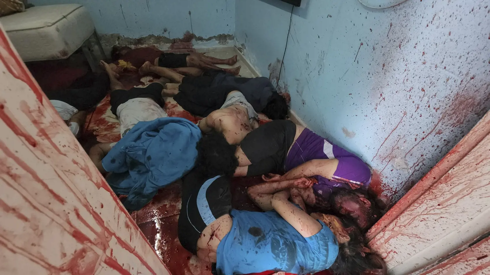 JB 11 Kfar Azza - POZOR NA SILNÝ GRAFICKÝ OBSAH!!! Telá izraelských civilistov ležia v kaluži krvi v dome, kde sa zhromaždili pri palestínskom raketovom útoku z pásma Gazy v meste Kfar Azza, neďaleko hranice s Gazou na juhu Izraela 7. októbra 2023. Izraelské zdravotnícke zdroje uviedli, že masívny útok palestínskych militantov na Izrael si vyžiadal už najmenej 300 obetí na životoch. Ďalších minimálne 1590 ľudí bolo zranených, pričom mnohí z nich utrpeli zranenia vážneho charakteru. Túto informác