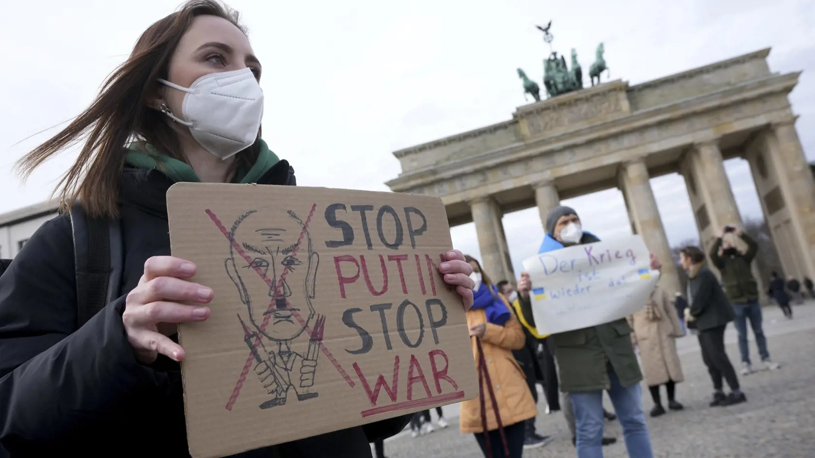 JB 25 Berlín - Ľudia držia transparenty a ukrajinské zástavy počas protestného zhromaždenia proti ruským útokom na Ukrajine pred Brandenburskou bránou v Berlíne 24. februára 2022. Ruské pozemné sily začali vo štvrtok vstupovať na územie Ukrajiny, informovala agentúra AFP s odvolaním sa na ukrajinskú pohraničnú stráž. Podľa nej ruské pozemné sily prešli na Ukrajinu z viacerých smerov. Ruské tanky a iná ťažká technika prekročili hranicu v niekoľkých severných regiónoch a na juhu z ukrajinského pol