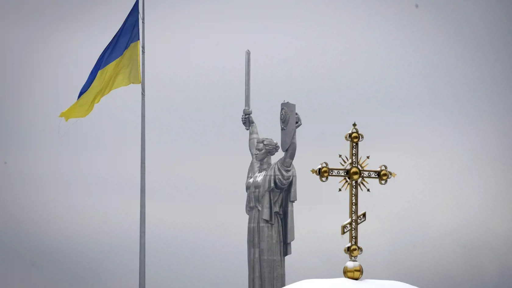 WA 39 Kyjev - Na snímke zľava ukrajinská vlajka, pamätník Veľkej vlasteneckej vojny a kríž na území pravoslávneho kláštora Kyjevsko-pečerská lavra v Kyjeve v utorok 22. novembra 2022. Ukrajinské bezpečnostné zložky vykonávala v utorok raziu na území pravoslávneho kláštora. Bezpečnostná služba Ukrajiny (SBU) vo svojom vyhlásení uviedla, že ide o zásah proti nebezpečným aktivitám ruských tajných služieb na Ukrajine. Kyjevsko-pečerská lavra bola pred rokmi štátom prevedená do vlastníctva ukrajinske