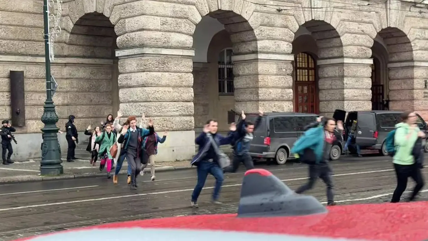 Študenti Filozofickej fakulty UK v Prahe utekajúci pred útočníkom
