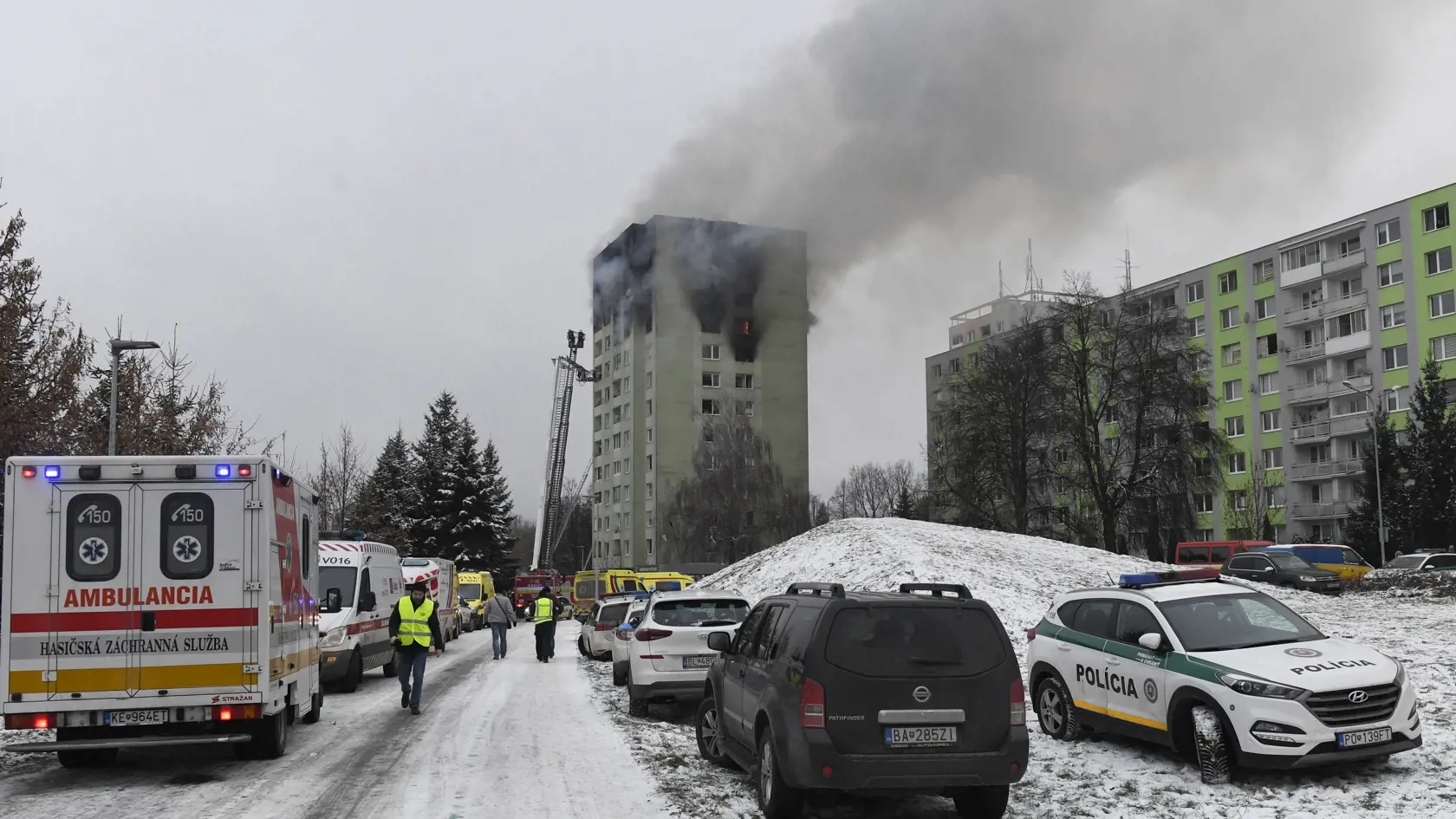 Hasiči a policajti počas zásahu na mieste výbuchu a požiari bytového domu 6. decembra 2019 v Prešove. Požiar mal vzniknúť po výbuchu horných poschodí 12 podlažnej bytovky pred 12.15 h. Polícia zatiaľ potvrdila štyri obete.  FOTO TASR - František Iván 