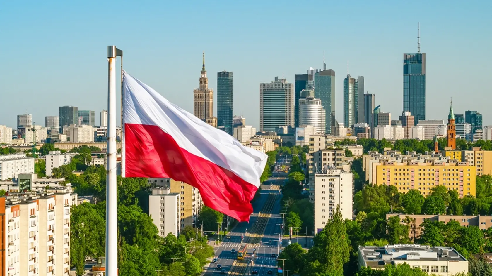 Polish national white and red flag against skyscrapers in Warsaw city center, aerial landscape under clear blue sky