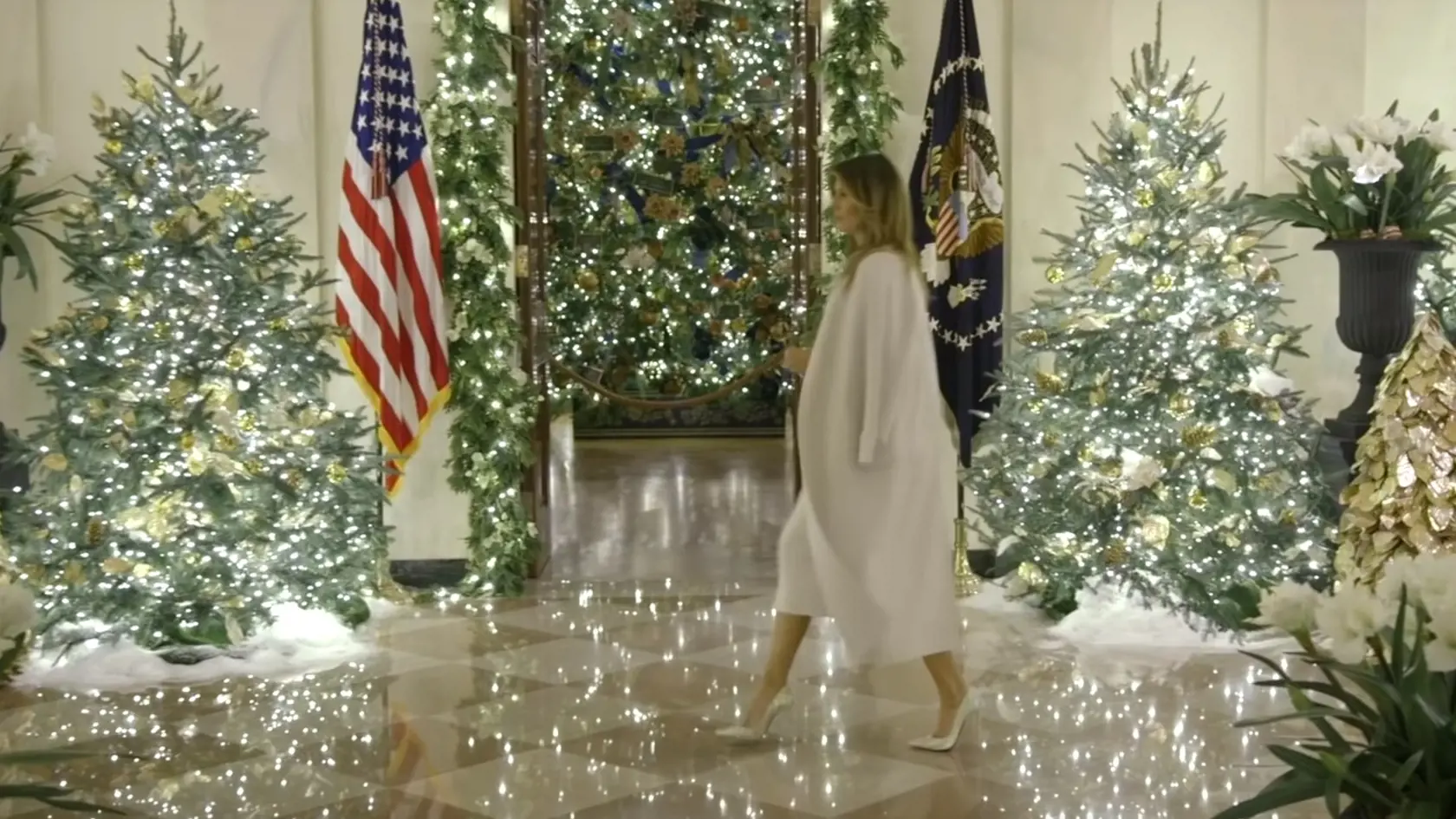 Melanie Trumpová prezentuje vianočný výzdobu Bieleho domu 2019. Siaha po kabáte prehodenom cez plecia, ktorý jej slúži ako barlička.