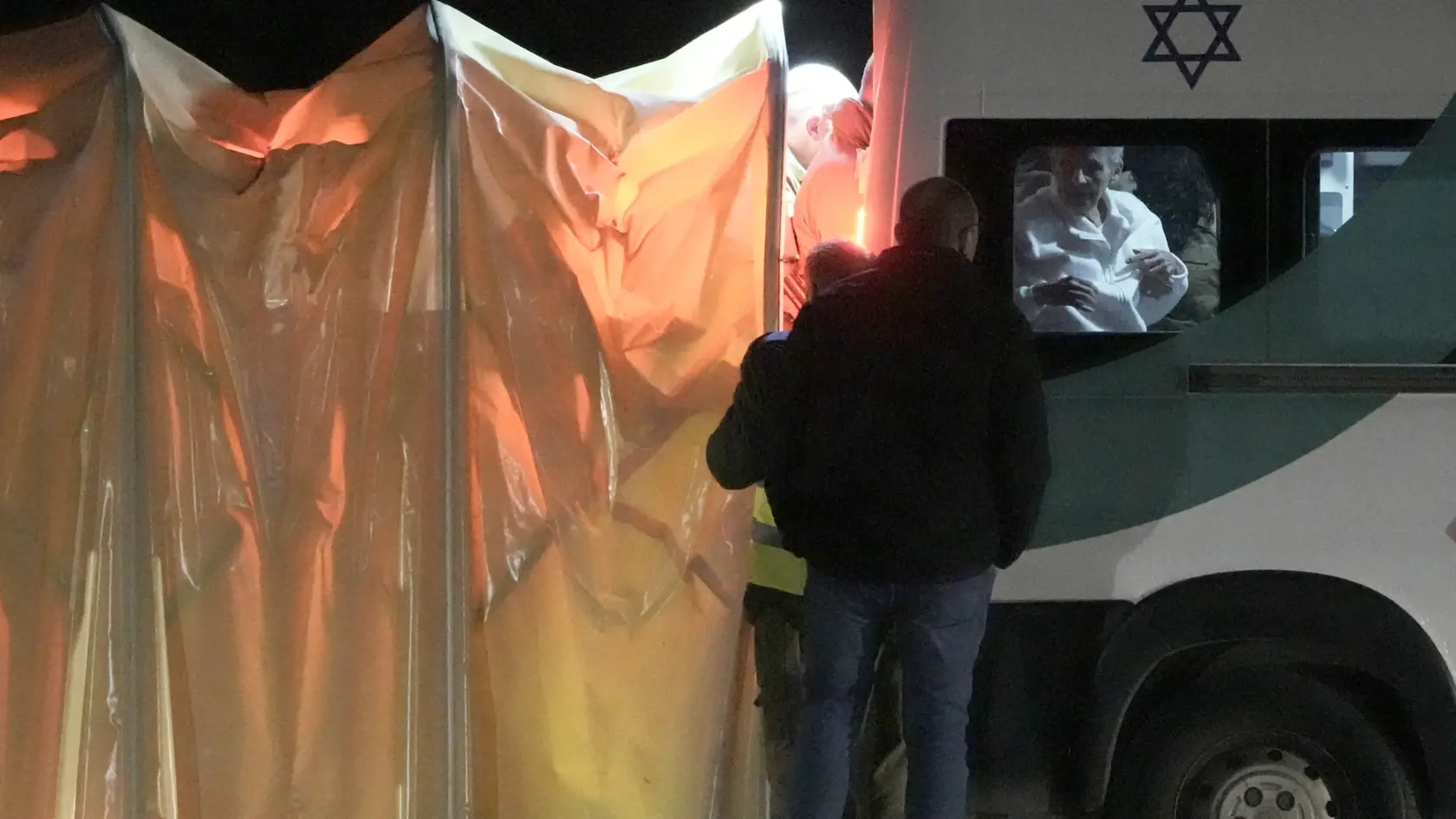 Personál pomáha staršiemu mužovi v minibuse, ktorý preváža ďalšiu skupinu rukojemníkov unesených z juhu Izraela do palestínskeho Pásma Gazy v Tel Avive v utorok 28. novembra 2023.