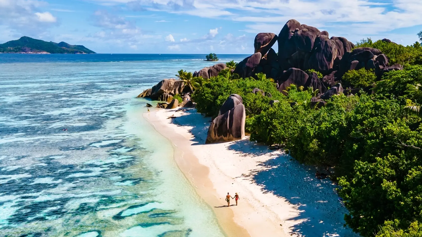Anse Source d'Argent, La Digue Seychelles, a young couple of Caucasian men and Asian women on a tropical beach during a luxury vacation in Anse Source d'Argent, La Digue Seychelles