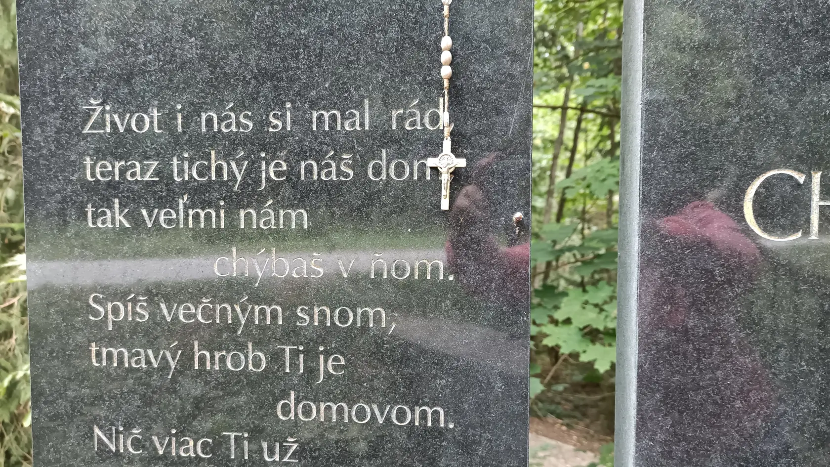 Takýto nápis je na pomníku. Ten zdobí aj ruženec.