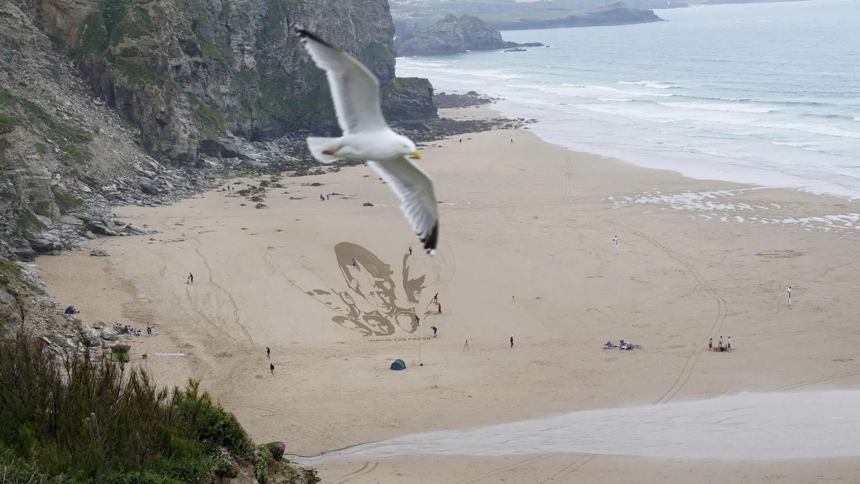 JB 10 Newquay - Čajka lieta nad aktivistami, ktorí kreslia v piesku na pláži pred summitom G7, siedmich najvyspelejších krajín sveta v meste Newquay, na juhu Anglicka 10. júna 2021. Summit lídrov priemyselne najvyspelejších krajín zo skupiny G7 sa uskutoční v britskom Cornwalle 11.- 13. júna. FOTO TASR/AP

A seagull flies overhead as activists draw the heads of G7 leaders in the sand on the beach at Newquay, Cornwall, England, Thursday, June 10, 2021. G7 leaders and guests will meet in the the C