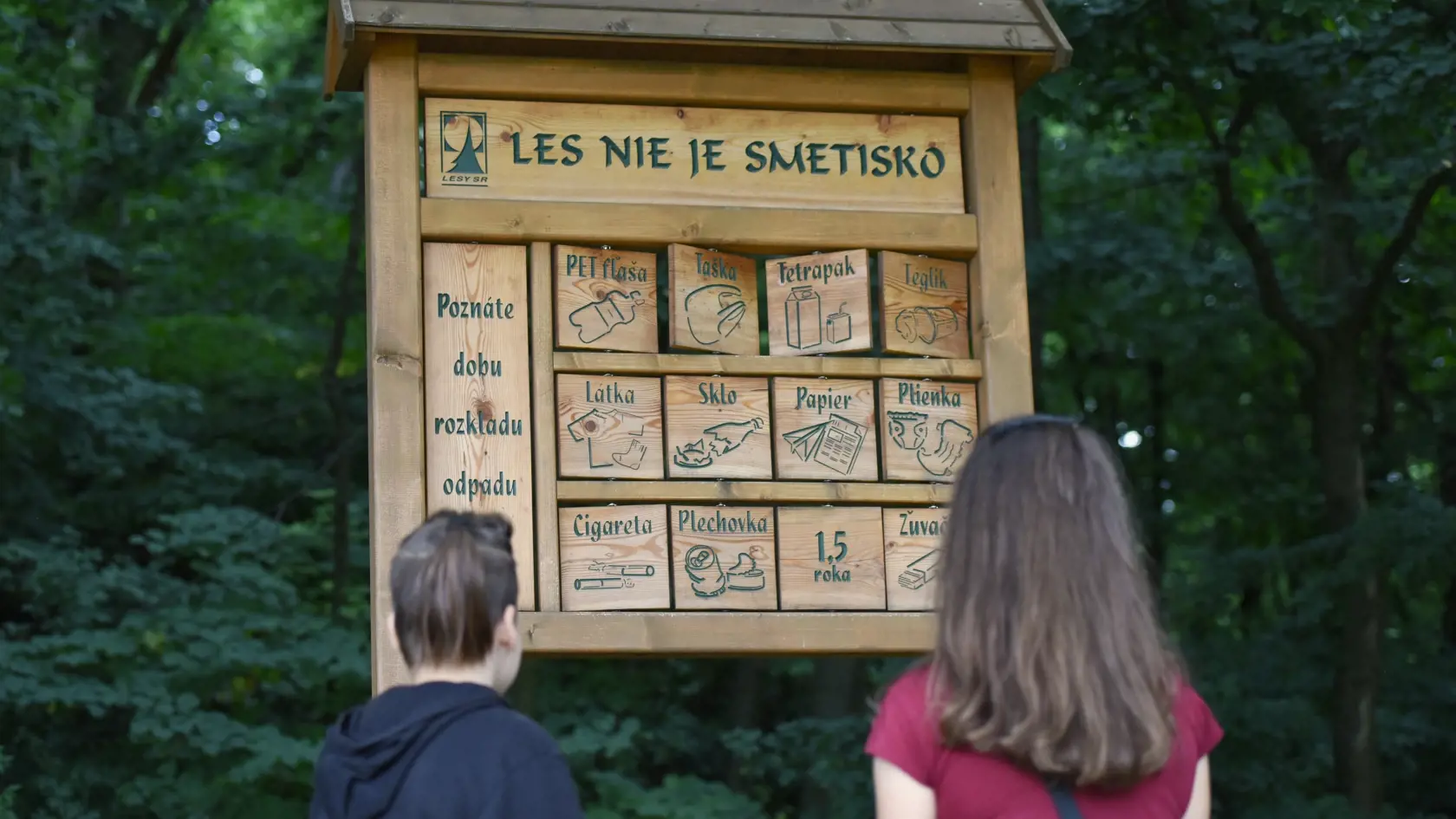 Na snímke turisti si pozerajú na tabuľu s názvom Les nie je smetisko pri ceste na zámok v Smoleniciach v nedeľu 19. júla 2020. FOTO TASR - Lukáš Grinaj