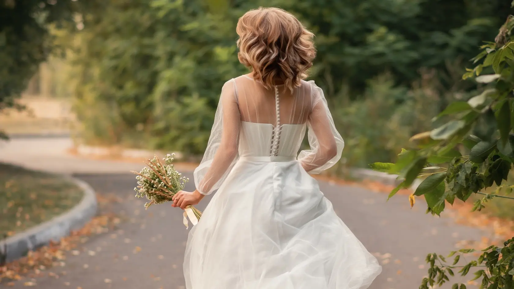 A photo of a bride in a white dress running along the road.