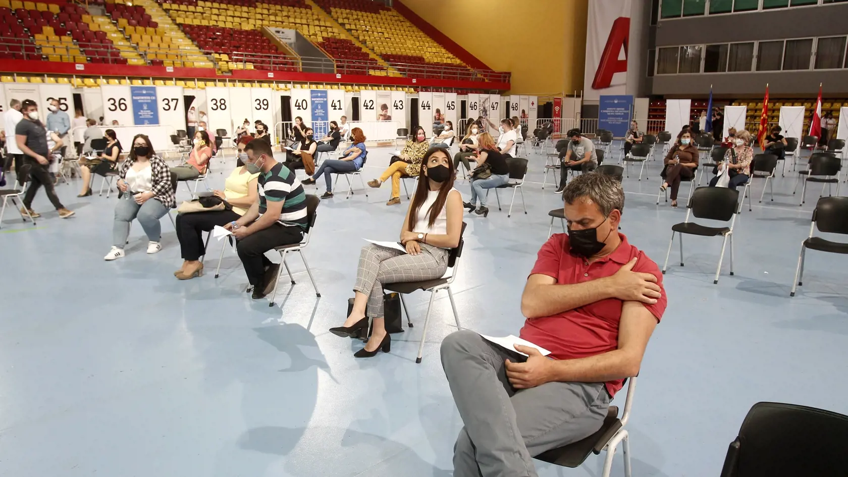 Na snímke ľudia čakajú po očkovaní vakcínou proti ochoreniu Covid-19 vo vakcinačnom centre, v Skopji 4. mája 2021. Európska únia (EÚ) začala v utorok balkánskym krajinám dodávať vakcíny proti koronavírusu od spoločností Pfizer-BioNTech. Informovala o tom agentúra AP s tým, že do regiónu doposiaľ dodávali očkovacie látky najmä Čína a Rusko.