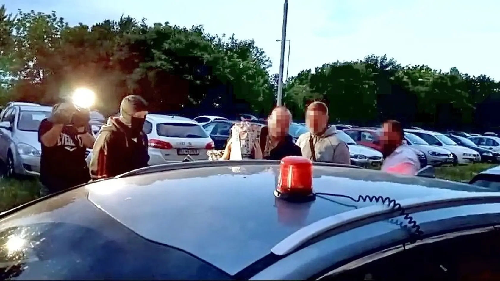 Manželka útočníka si cestou na výsluch tvár prekrývala novinami. 