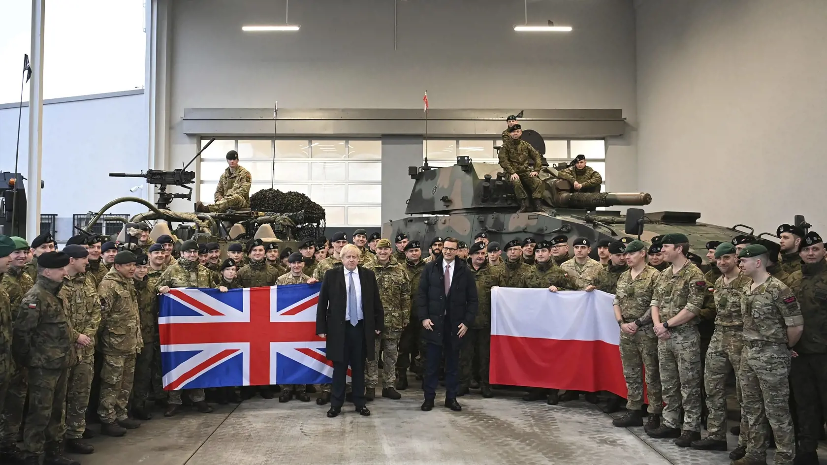 KK49 Varšava - Britský premiér Boris Johnson (vľavo) a poľský premiér Mateusz Morawiecki počas stretnutia  s britskými vojakmi umiestnenými v Poľsku na misii NATO vo Wesole neďaleko Varšavy 10. februára 2022. FOTO TASR/AP
British Prime Minister Boris Johnson, left, and his Polish counterpart Mateusz Morawiecki pose for a photograph with British and Polish troops during a visit to the Warszawska Brygada Pancerna military base near Warsaw,  Poland, Thursday, Feb. 10, 2022. Johnson was in Poland fo