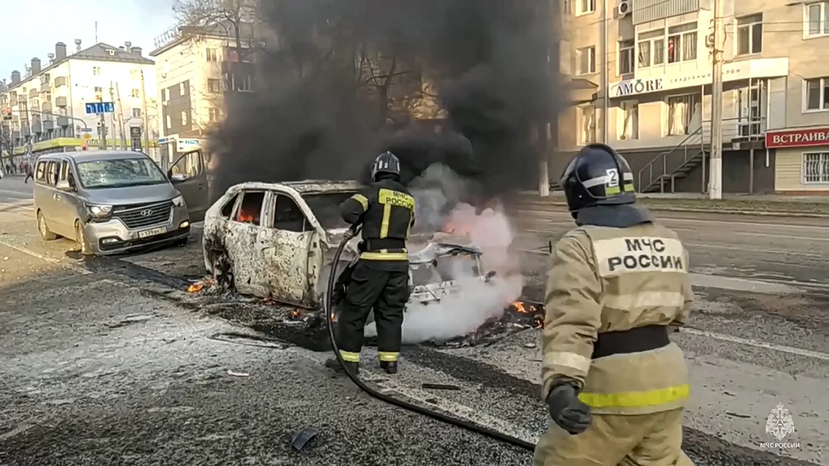 Na archívnej snímke z 30. decembra 2023 hasiči hasia horiace autá po ostreľovaní v ruskom Belgorode. Úrady ruskej Belgorodskej oblasti, ktorá hraničí s Ukrajinou, vo štvrtok oznámili, že niektoré školy zostanú zatvorené až do 19. januára 2024.
