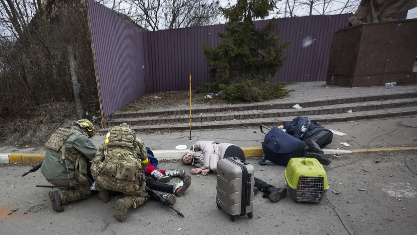 Ukrajinskí  vojaci pomahajú zraneným ľuďom ležiacim na ceste po ruskom ostreľovaní v meste Irpiň počas jedenásteho dňa ruskej invázie na Ukrajine v nedeľu 6. marca 2022.