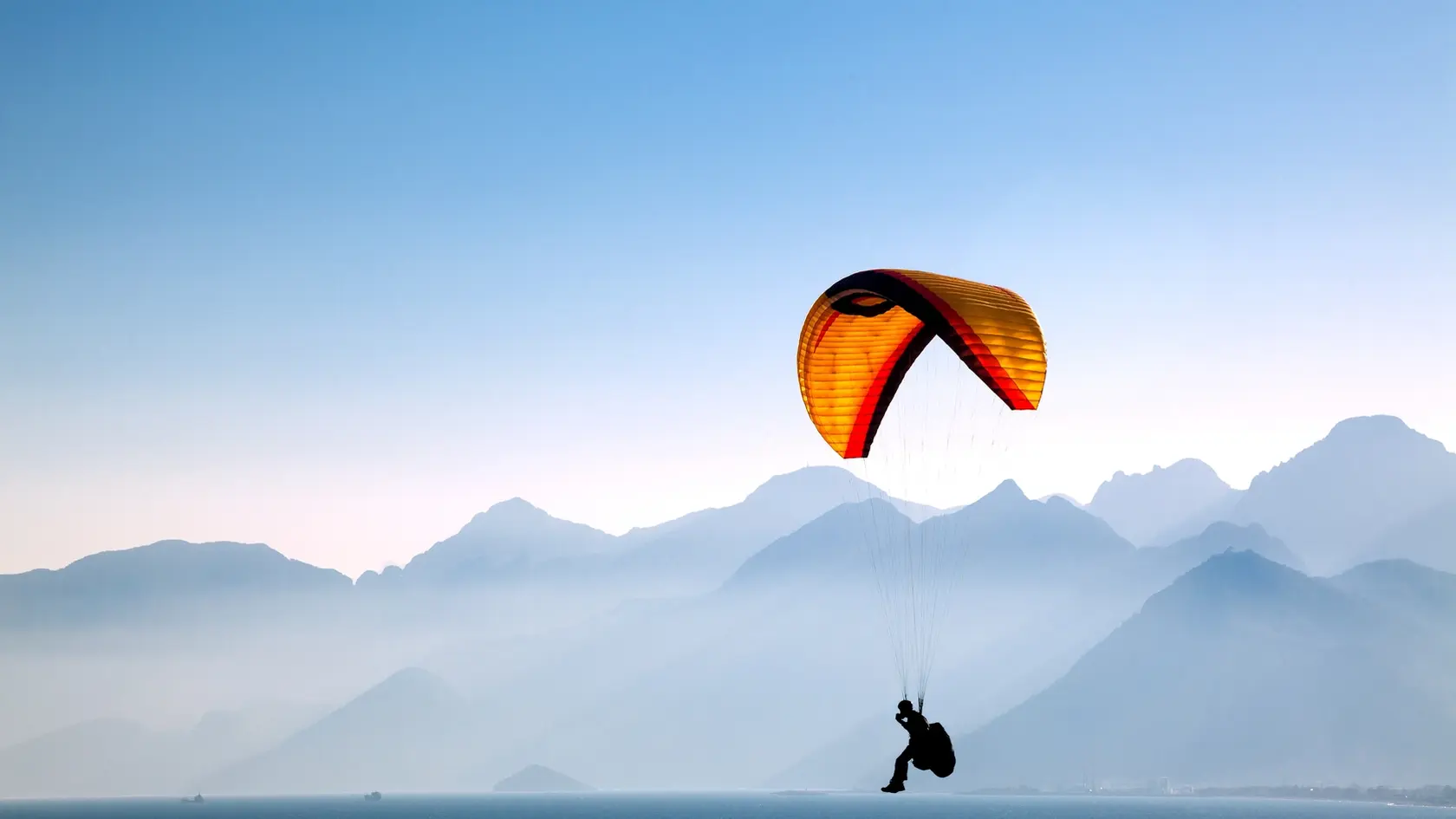 Silhouetted in the mountains with paragliding.