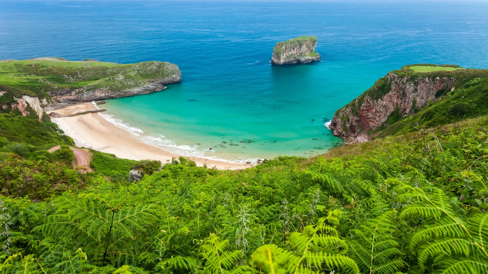 Ballota beach with the islet Castro, Llanes, Asturias , Spain