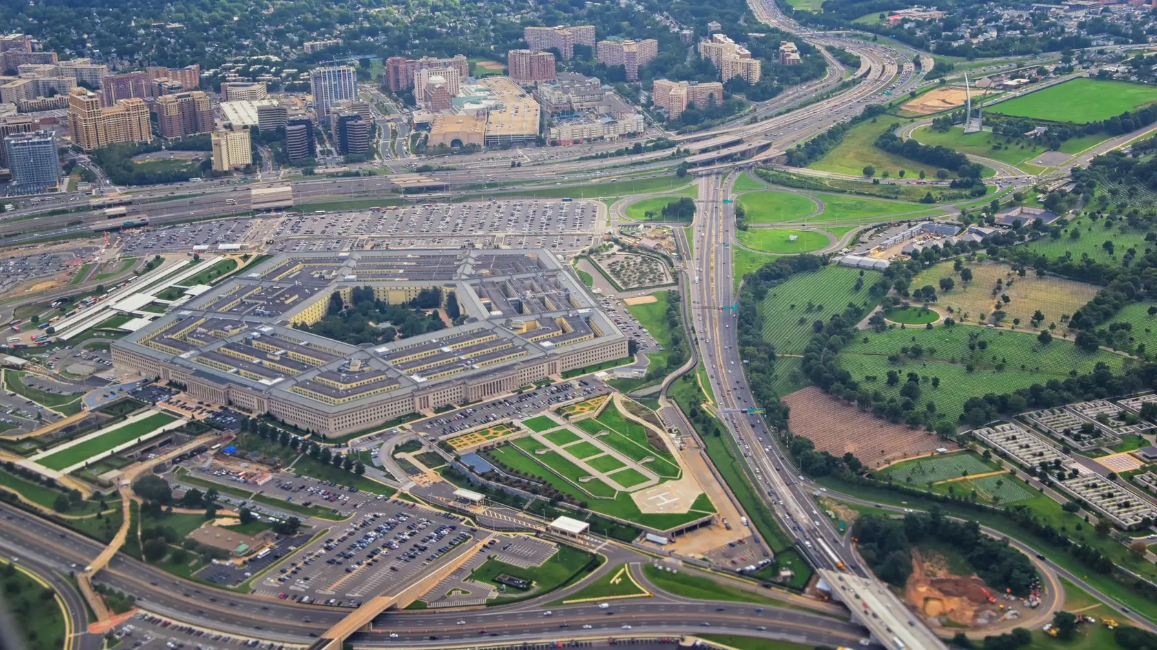 Aerial view of the United States Pentagon, the Department of Defense headquarters in Arlington, Virginia, near Washington DC, with I-395 freeway and the Air Force Memorial and Arlington Cemetery nearby.