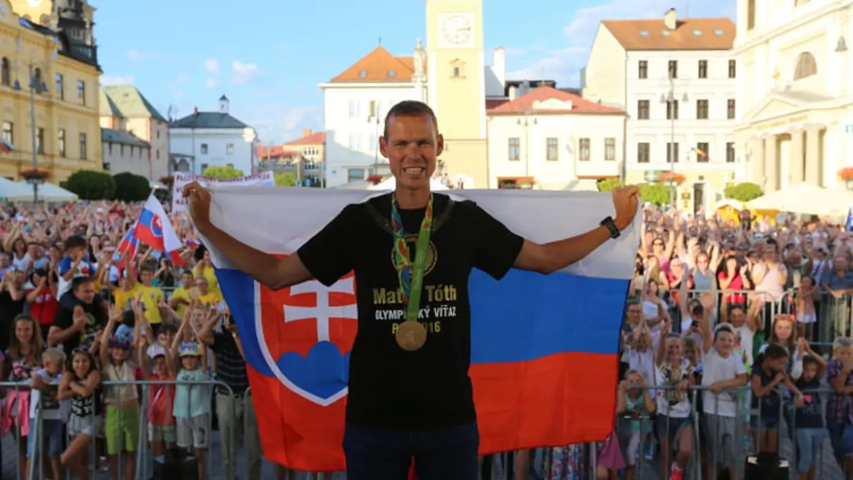 Matej Tóth so slovenskou vlajkou pózuje pred fanúšikmi v Banskej Bystrici.
