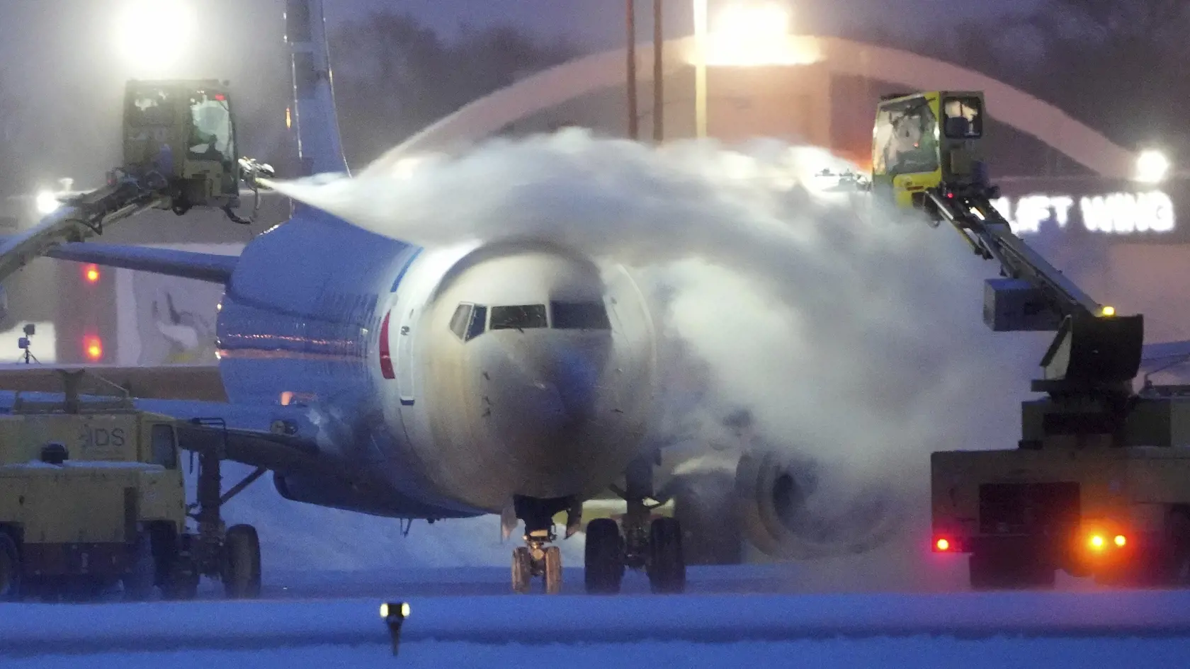 Na snímke odstraňovanie ľadu z lietadla spoločnosti American Airlines na medzinárodnom letisku v americkom Bloomingtone 22. decembra 2022.