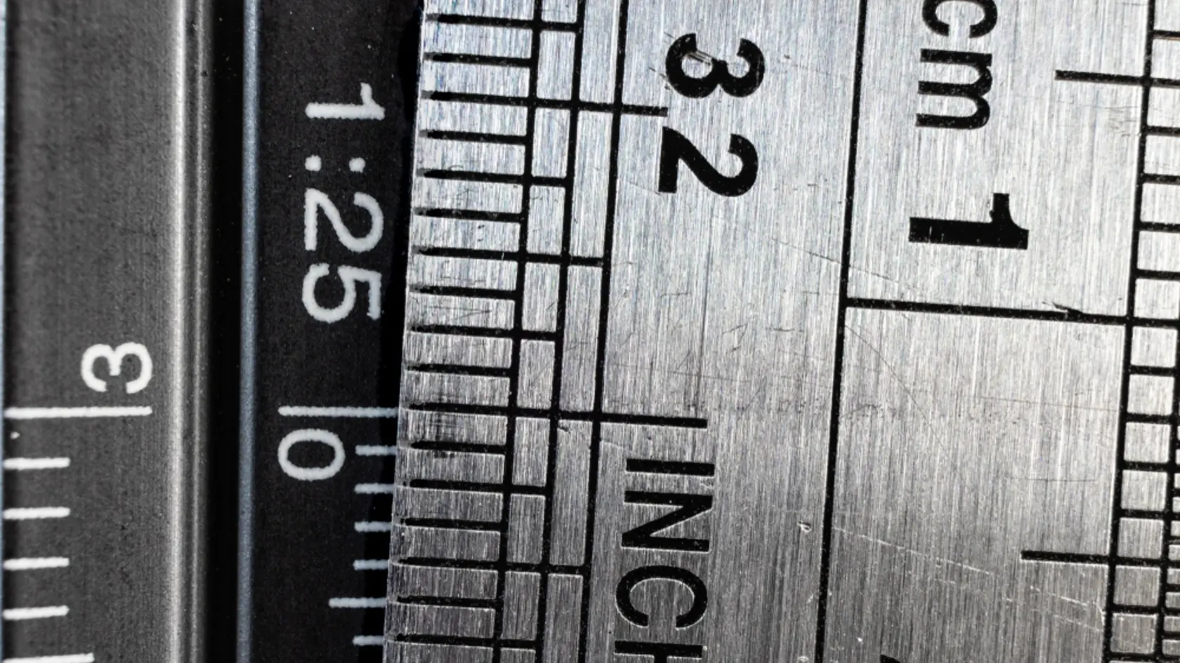 Close-up,Picture,Of,Two,Steel,Rulers,Showing,The,Size,Difference