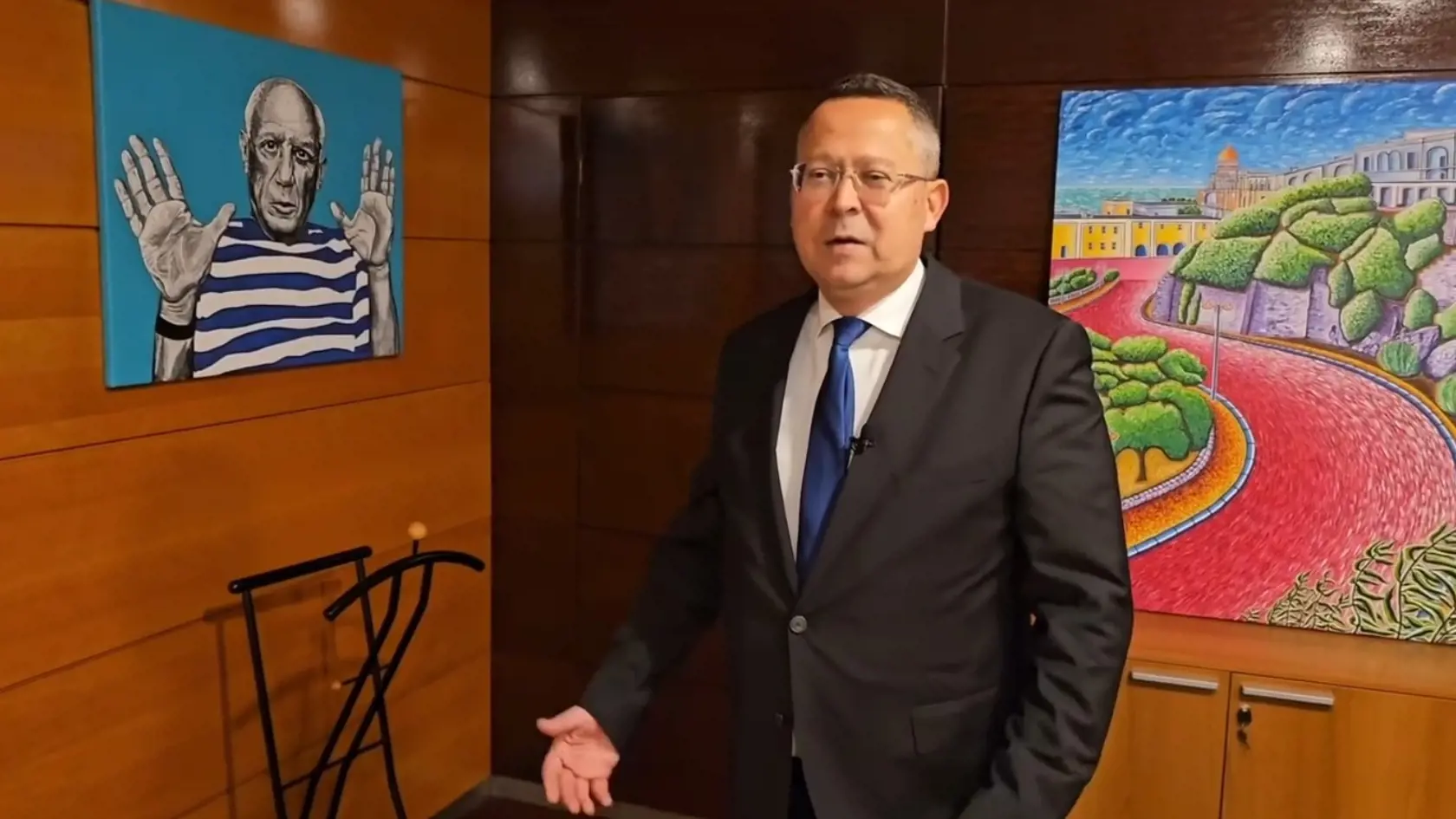Na snímke Ladislav Kamenický ukazuje galériu svojich obrazov v priestoroch ministerstva financií.