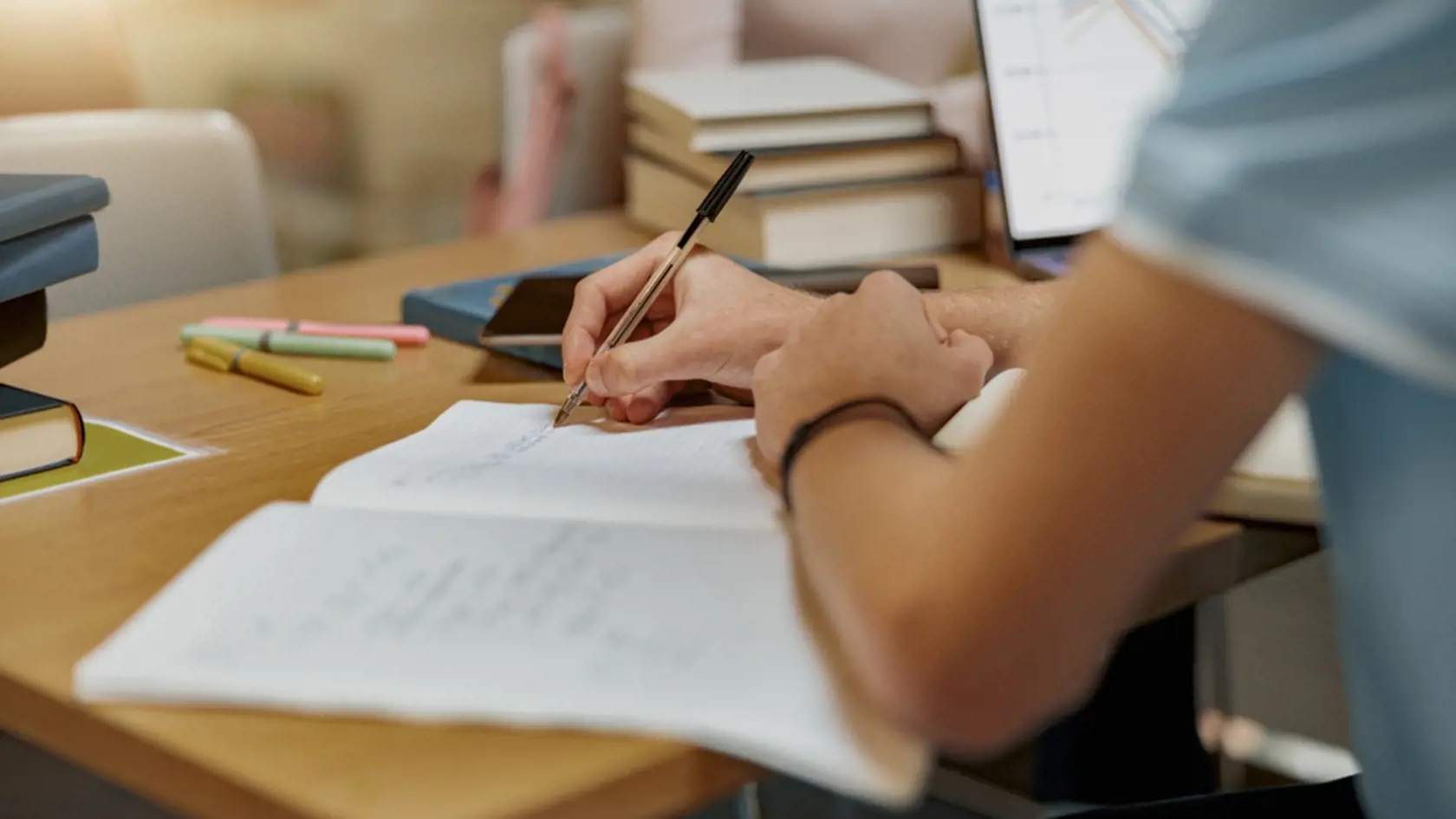 Close up of student sits in library, prepare for exam and making notes in notebook